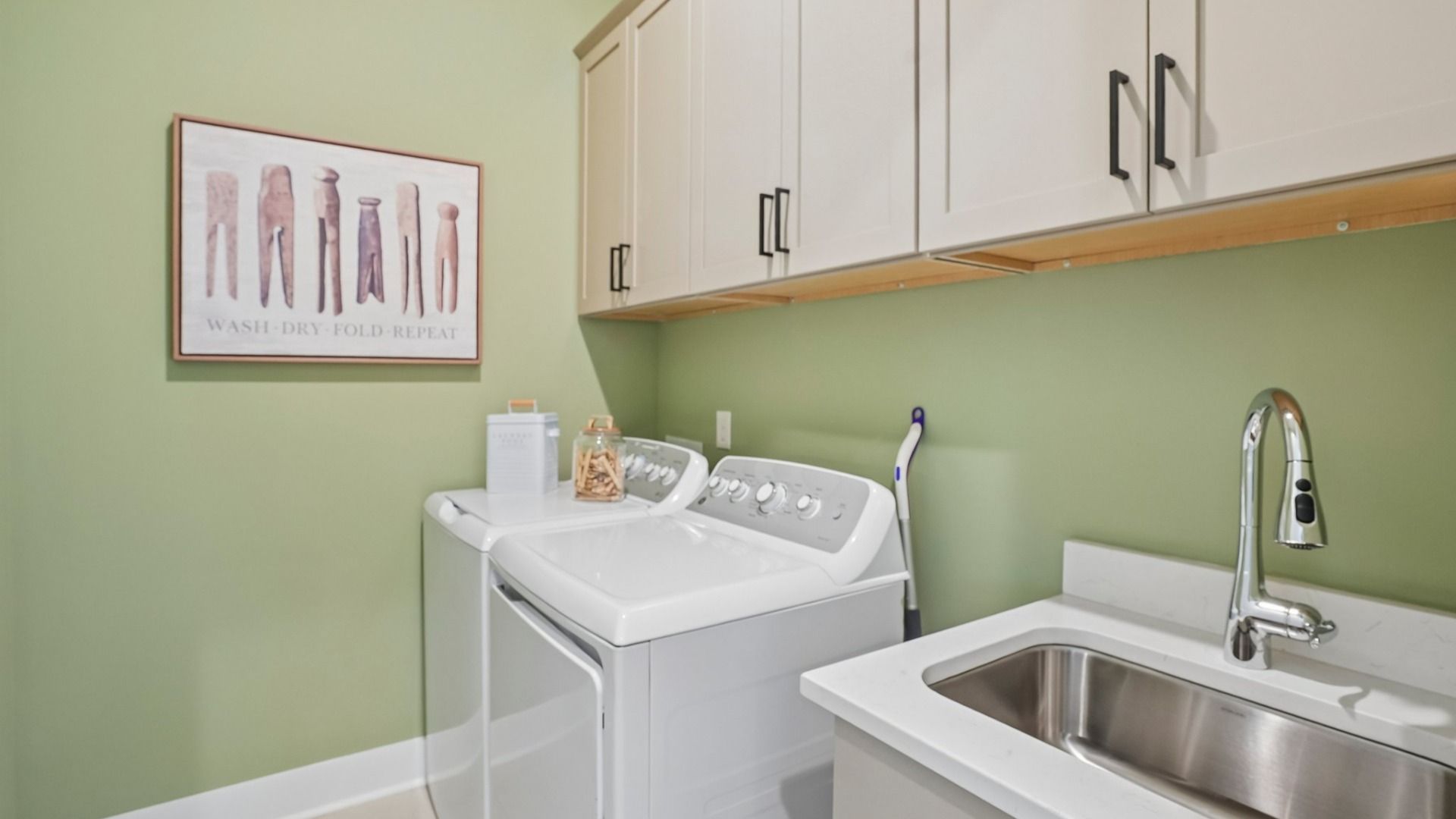 Dedicated laundry room with cabinets and sink