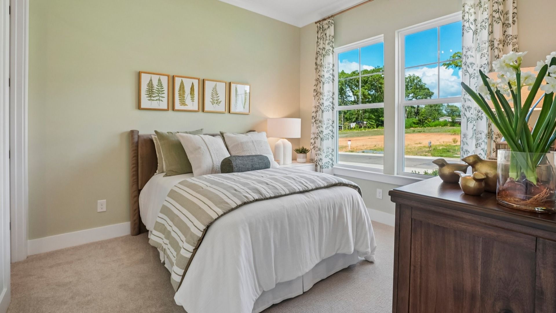 Secondary bedroom with carpet and windows