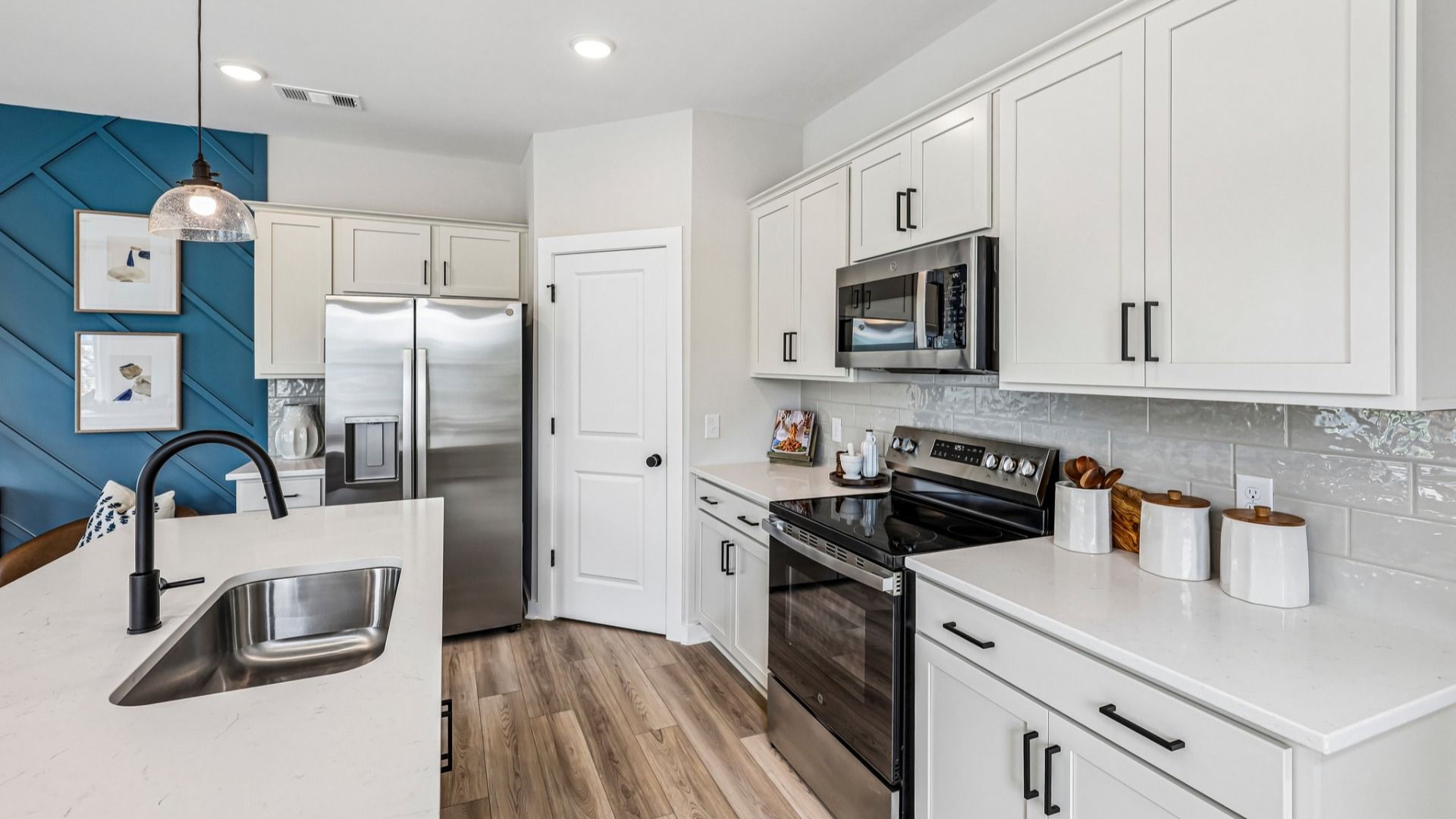 View of kitchen with quartz countertops, tile backsplash, and pendant lighting