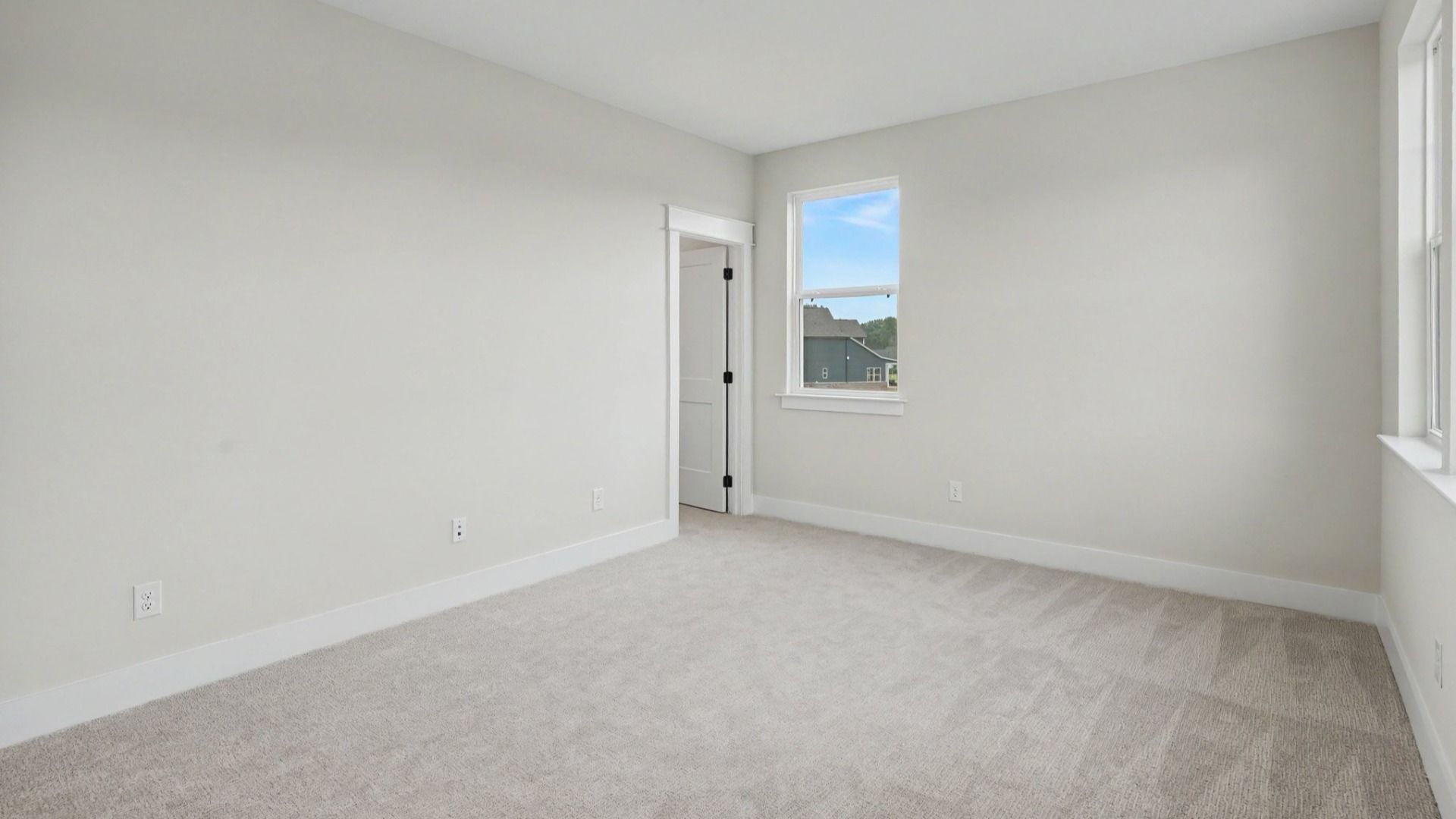 Secondary bedroom with windows and carpet