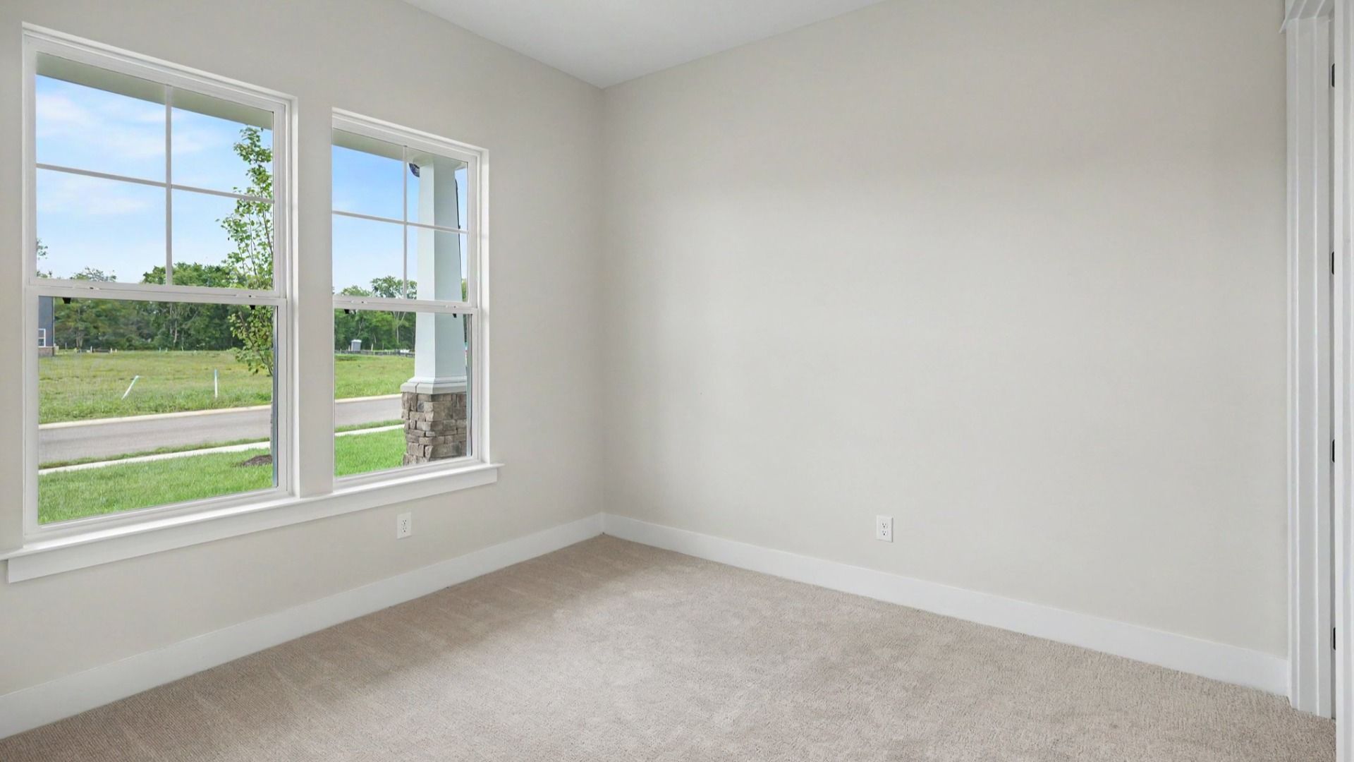 Secondary bedroom with windows and carpet