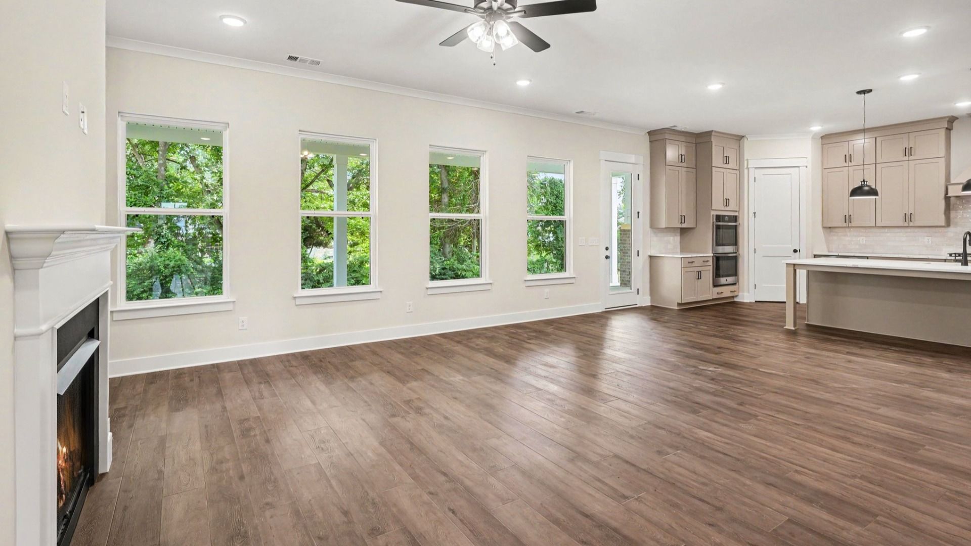 Gathering room with fireplace, ceiling fan, and hard surface flooring
