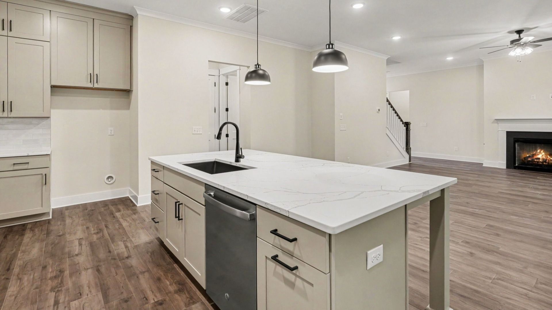 Kitchen with quartz countertops, tile backsplash, and light cabinetry