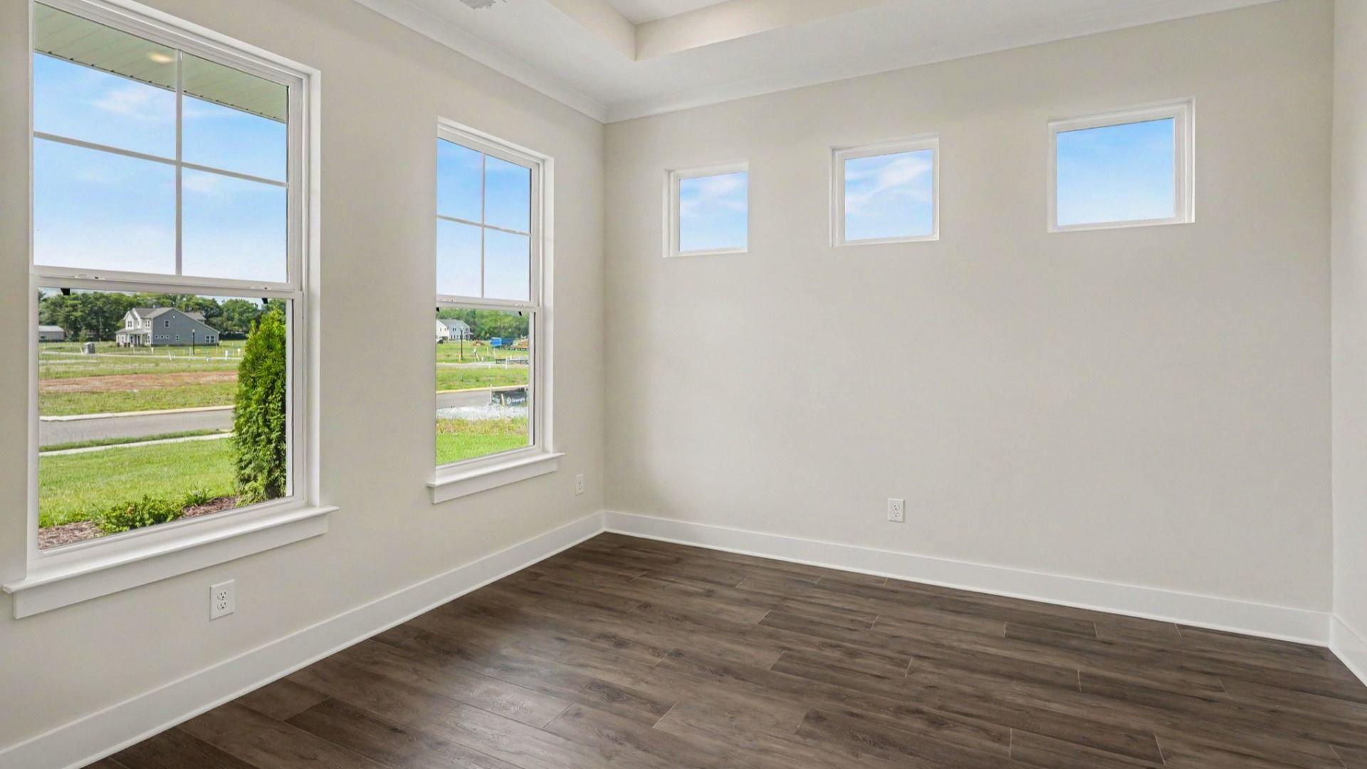 Dining space with tray ceiling, hard surface flooring, and windows
