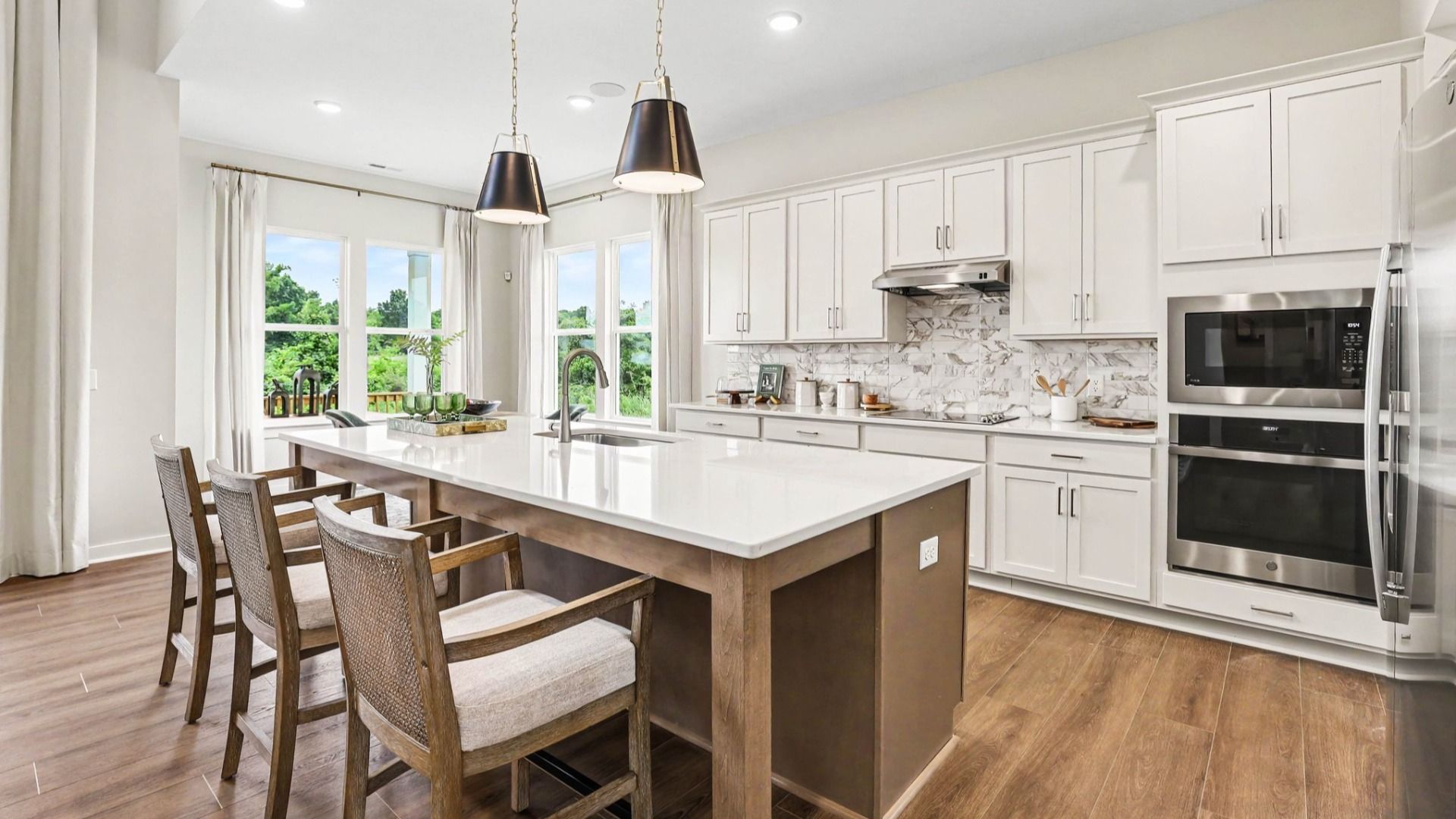 Kitchen with quartz countertops, tile backsplash, and pendant lighting