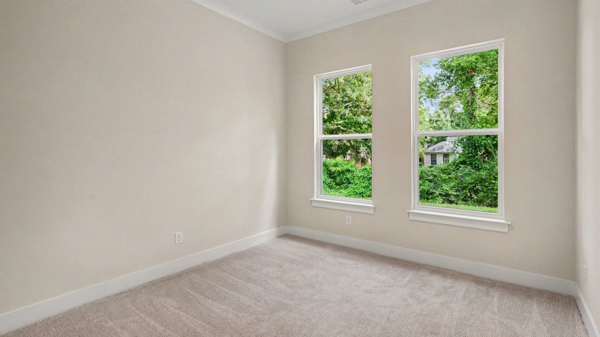 Secondary bedroom with carpet and windows