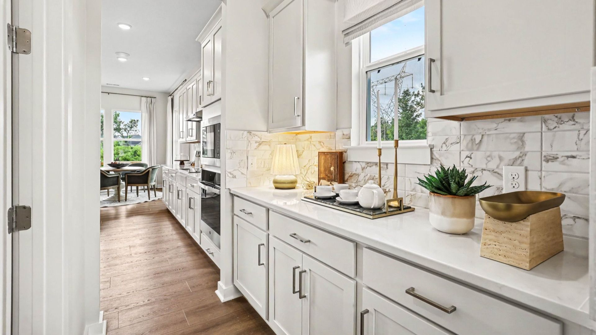 Side portion of kitchen with extra storage space, access to butler's pantry, and tile backsplash