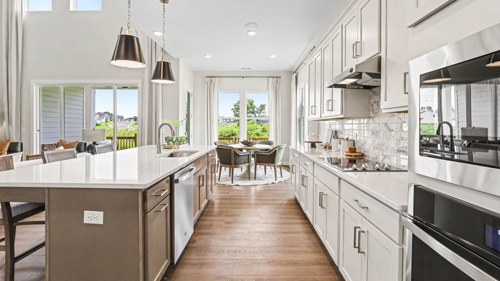 Kitchen with quartz countertops, tile backsplash, and pendant lighting