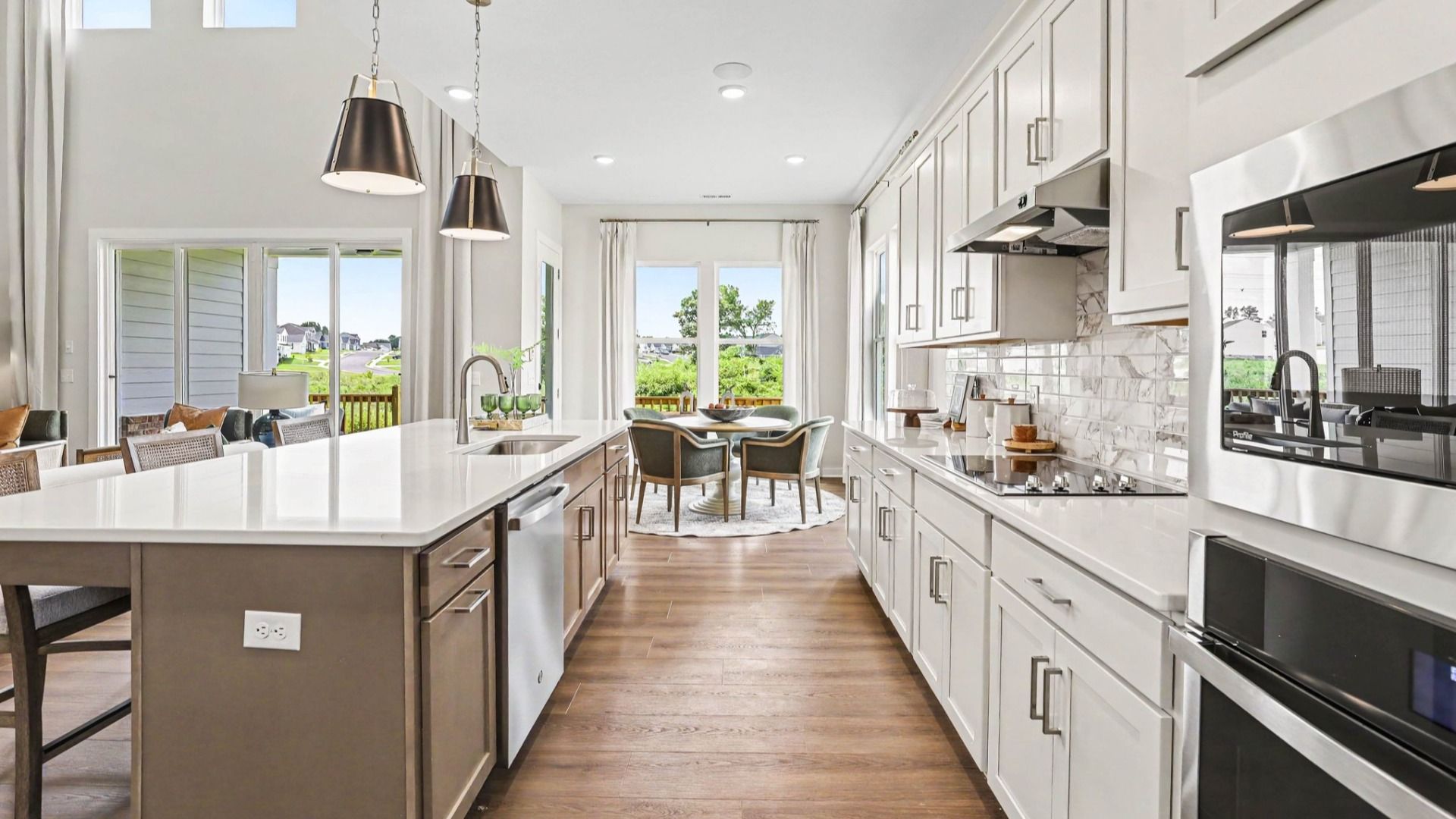 Kitchen with quartz countertops, tile backsplash, and light cabinetry