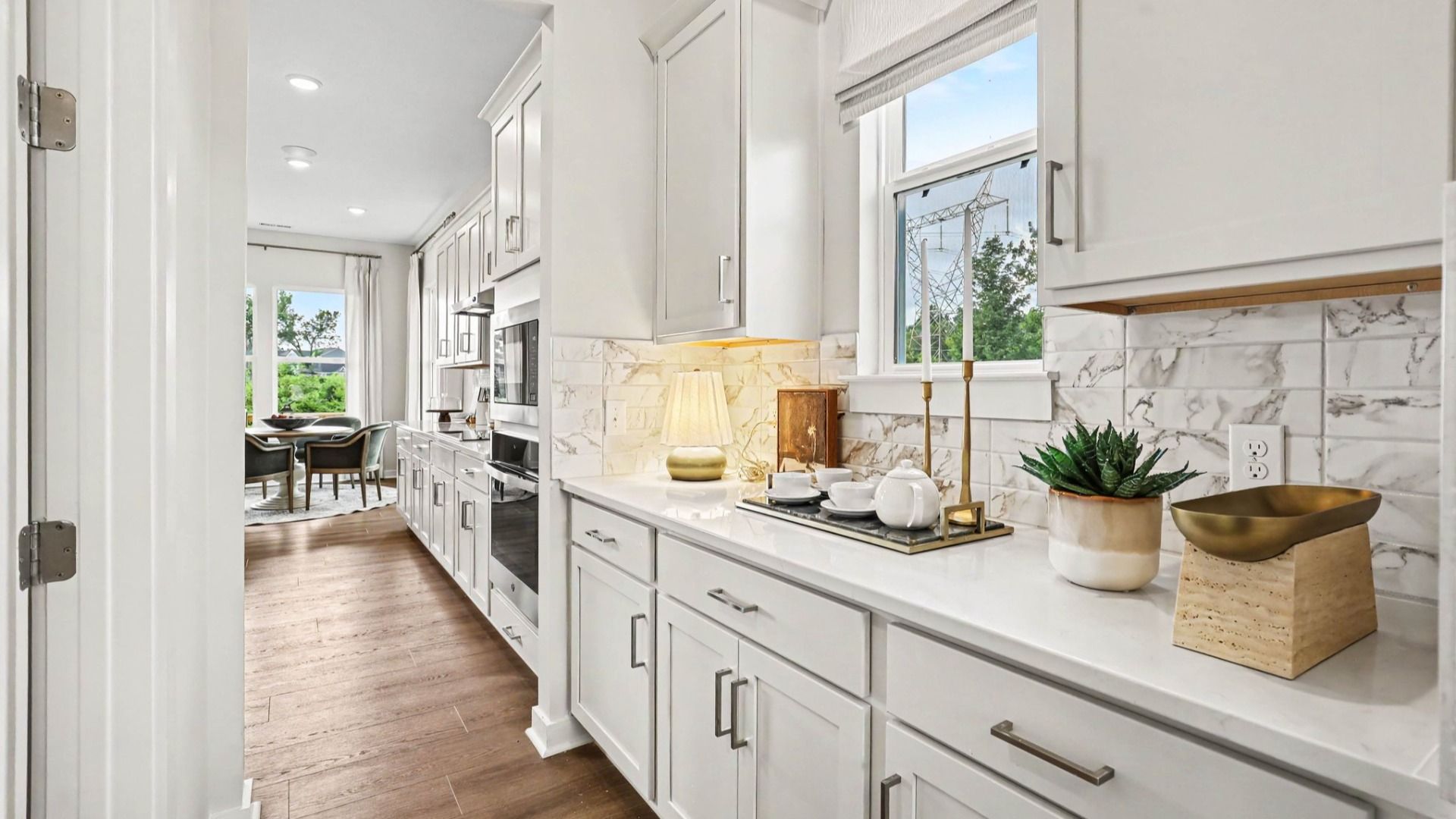 Side portion of kitchen with extra storage space, access to butler's pantry, and tile backsplash