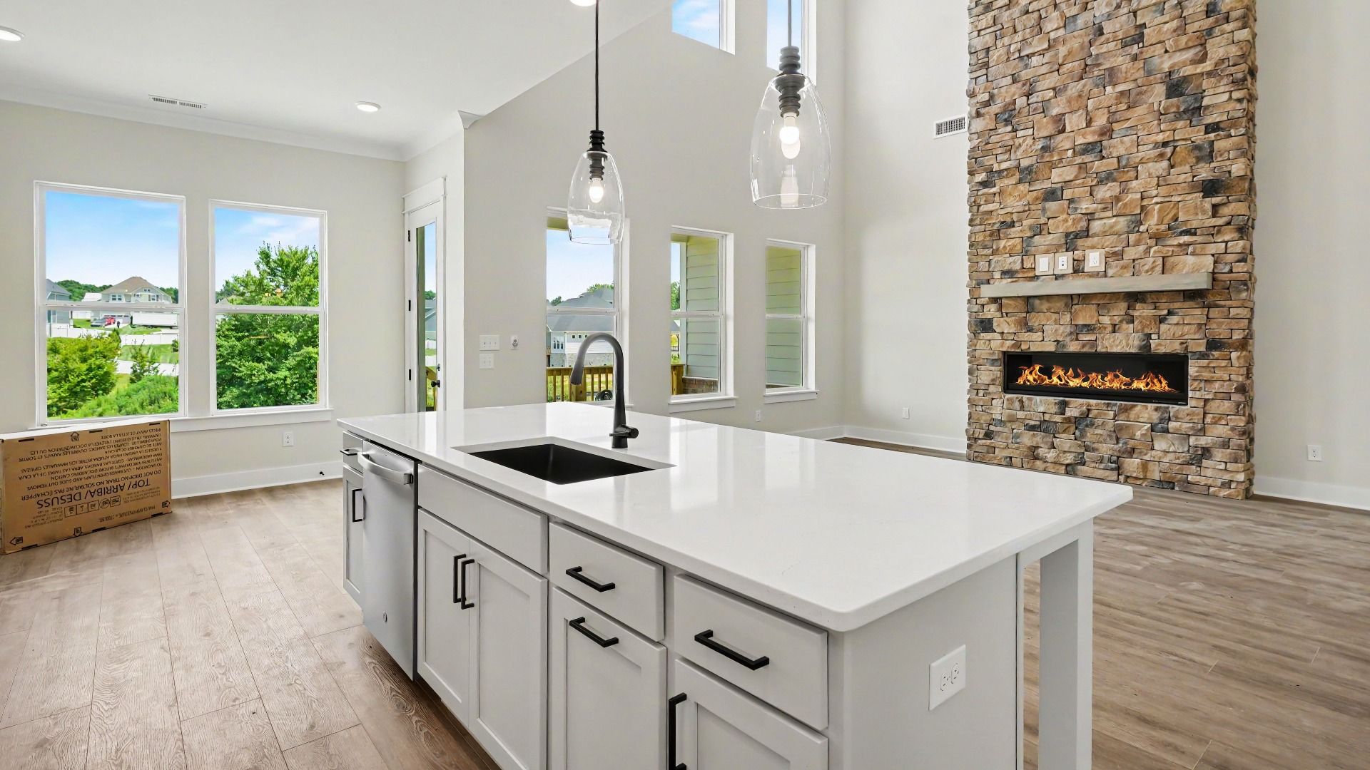 Kitchen with quartz countertops, pendant lighting, and view of gathering room