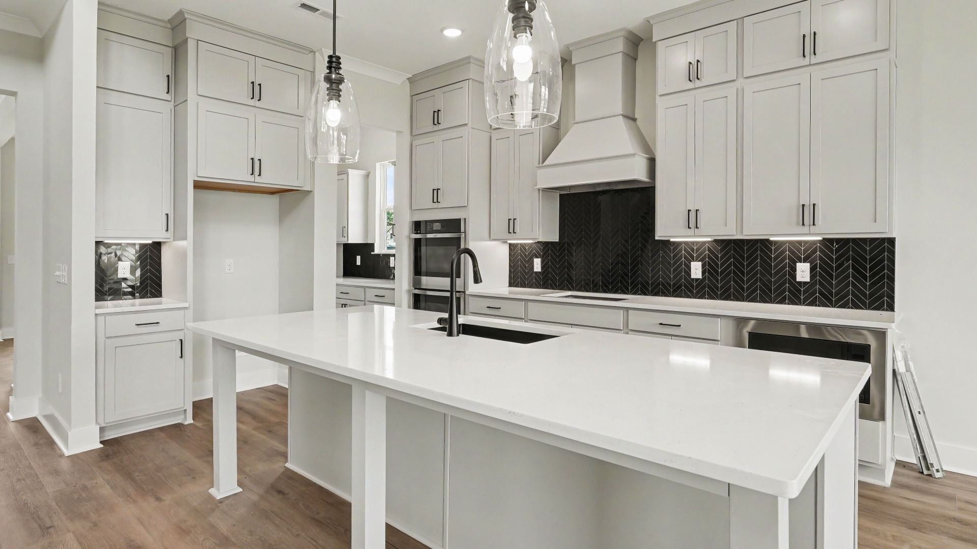 Kitchen with quartz countertops, pendant lighting, and tile backsplash