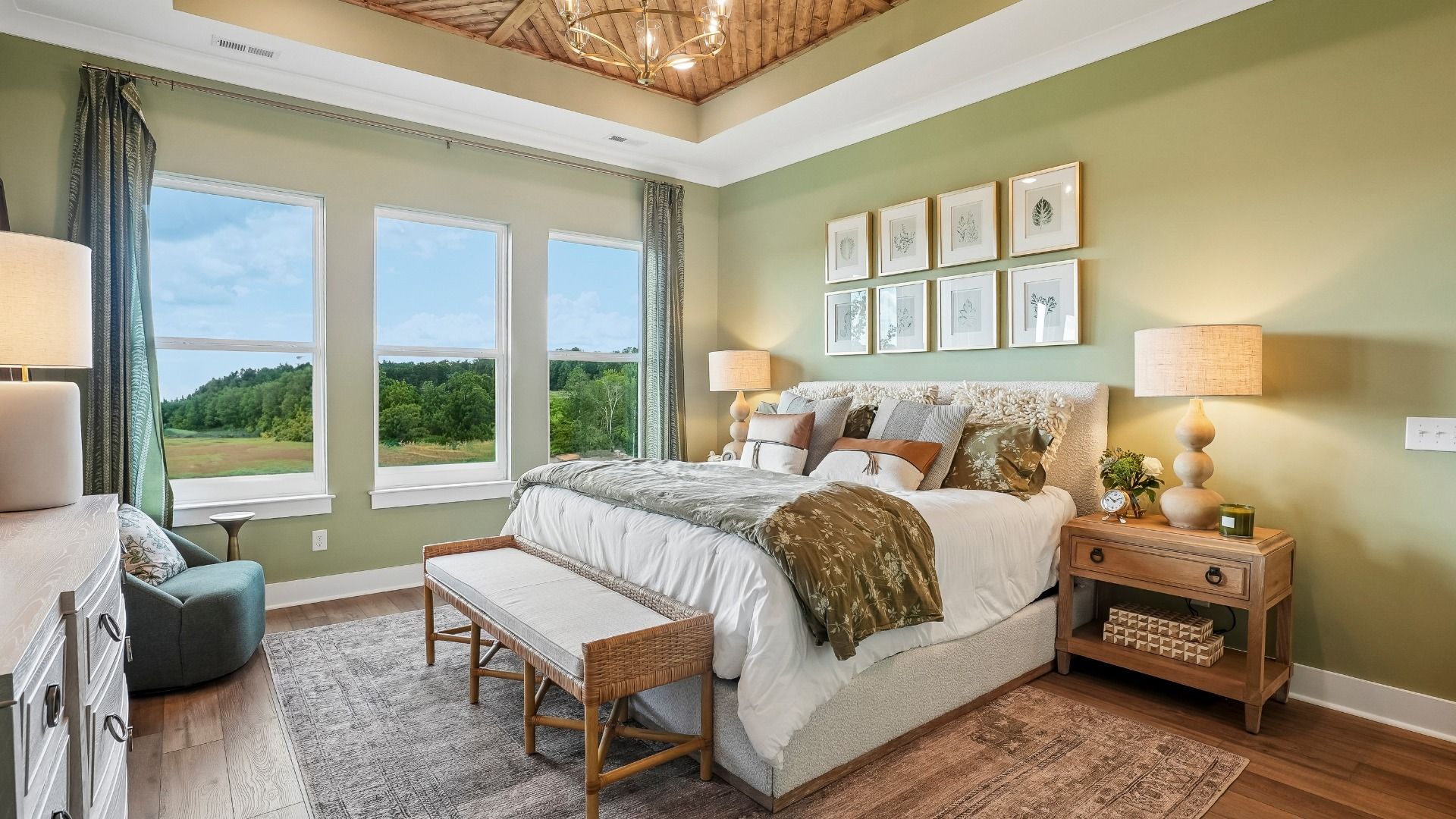 Primary suite with tray ceiling, hard surface flooring, and windows