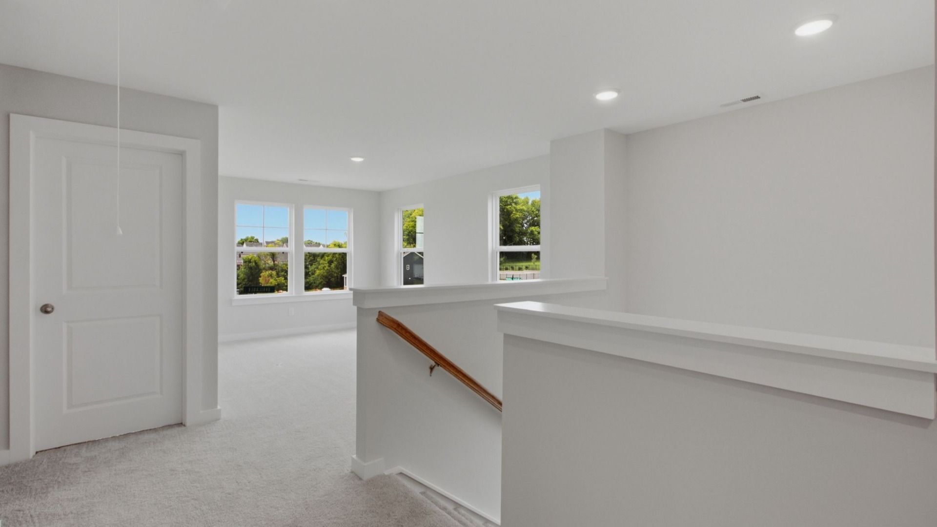 Second floor landing with nearby loft area and door to dedicated laundry room