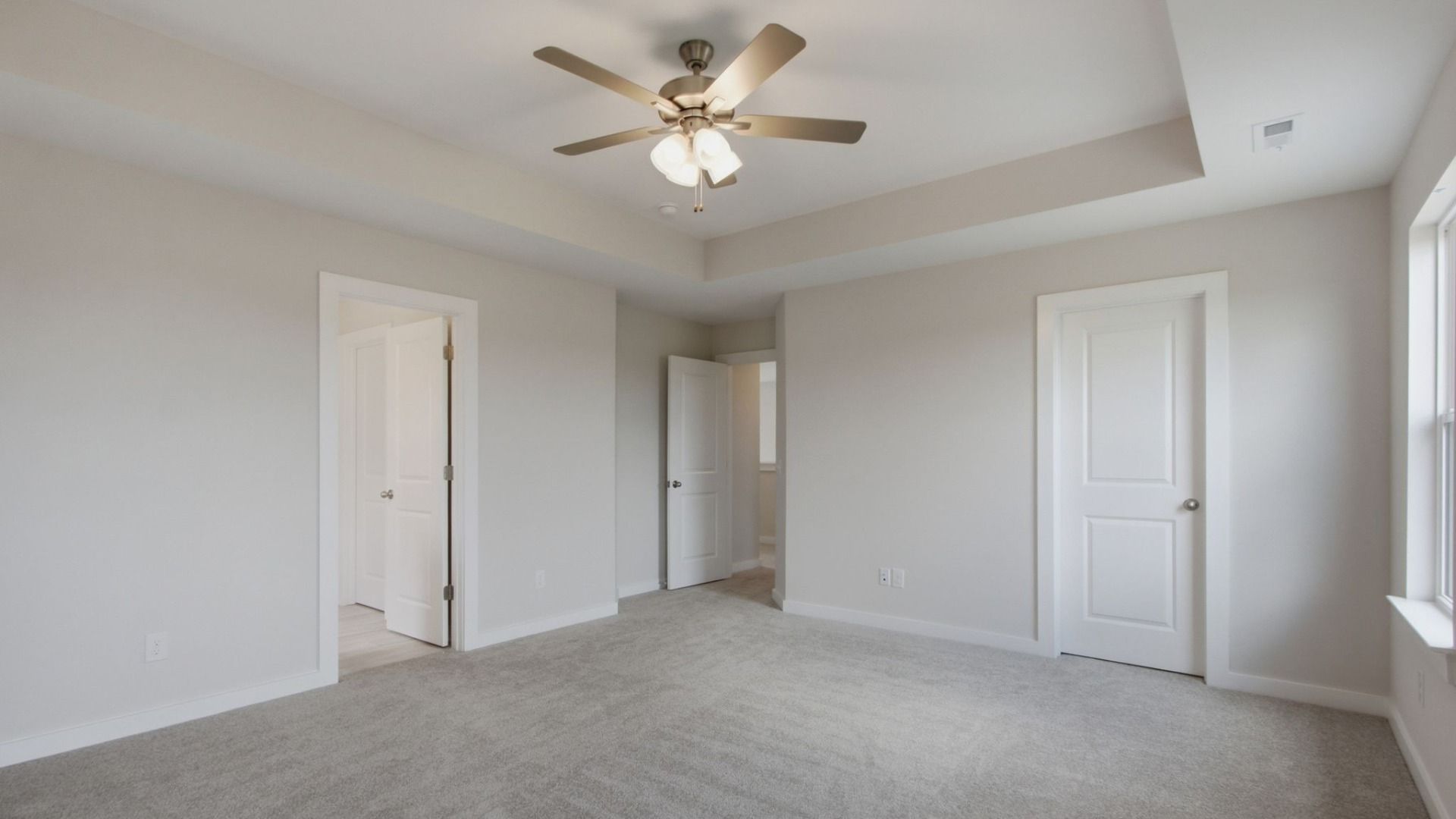 Large primary bedroom with doors to en-suite bathroom and large walk-in closet