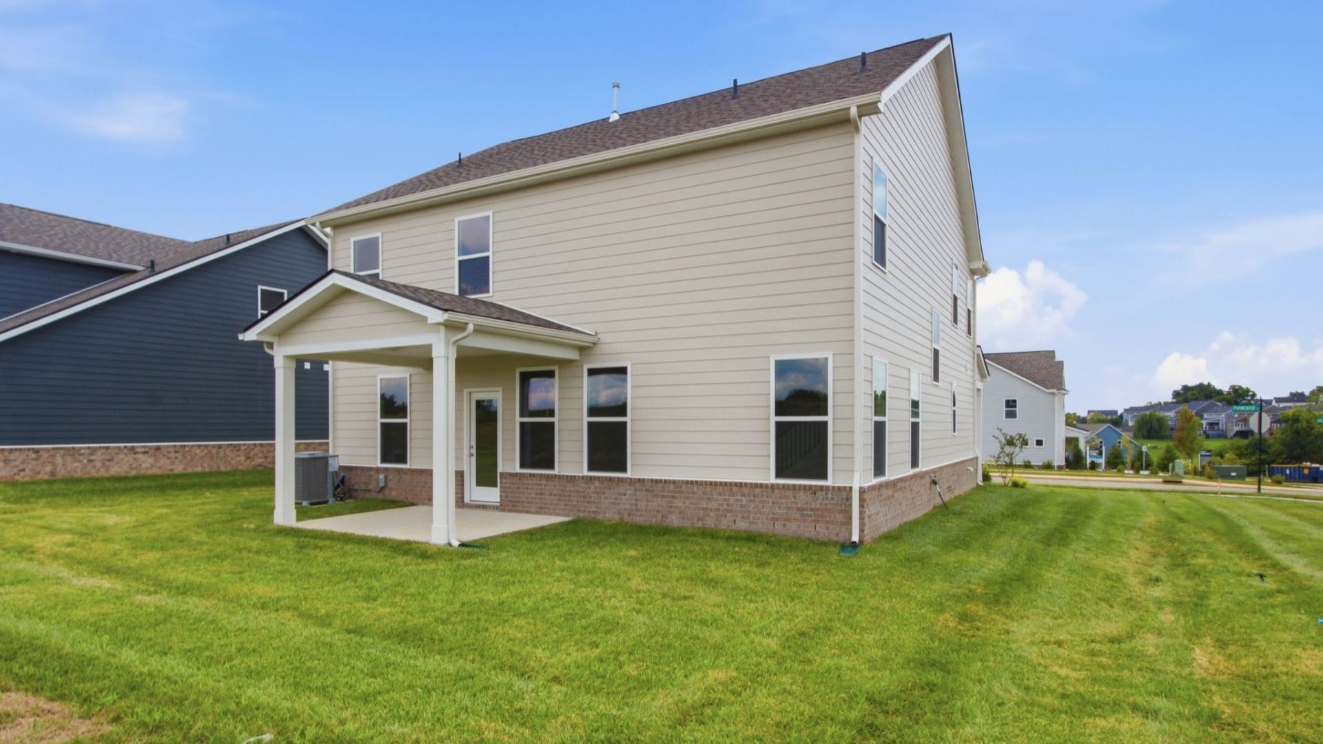Rear exterior of home with sodded backyard