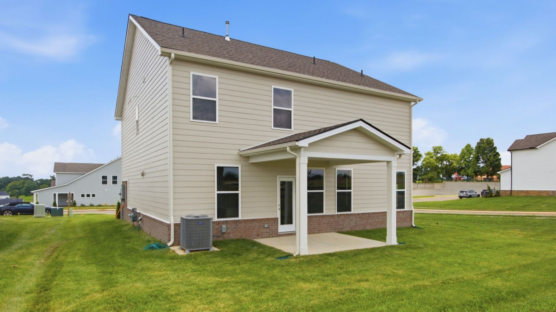 Rear exterior of home with sodded backyard