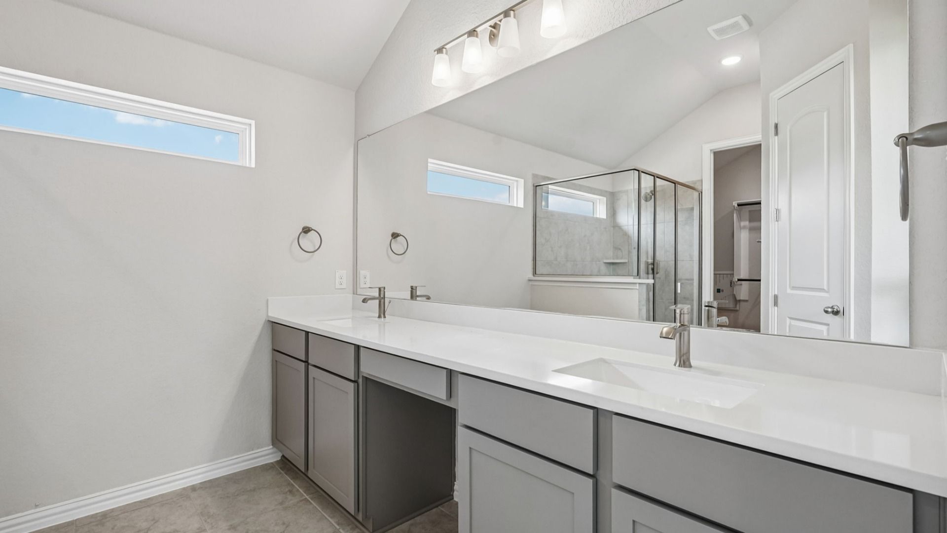 Owner's bath features a double vanity with space for a chair and a shower with a marble seat.