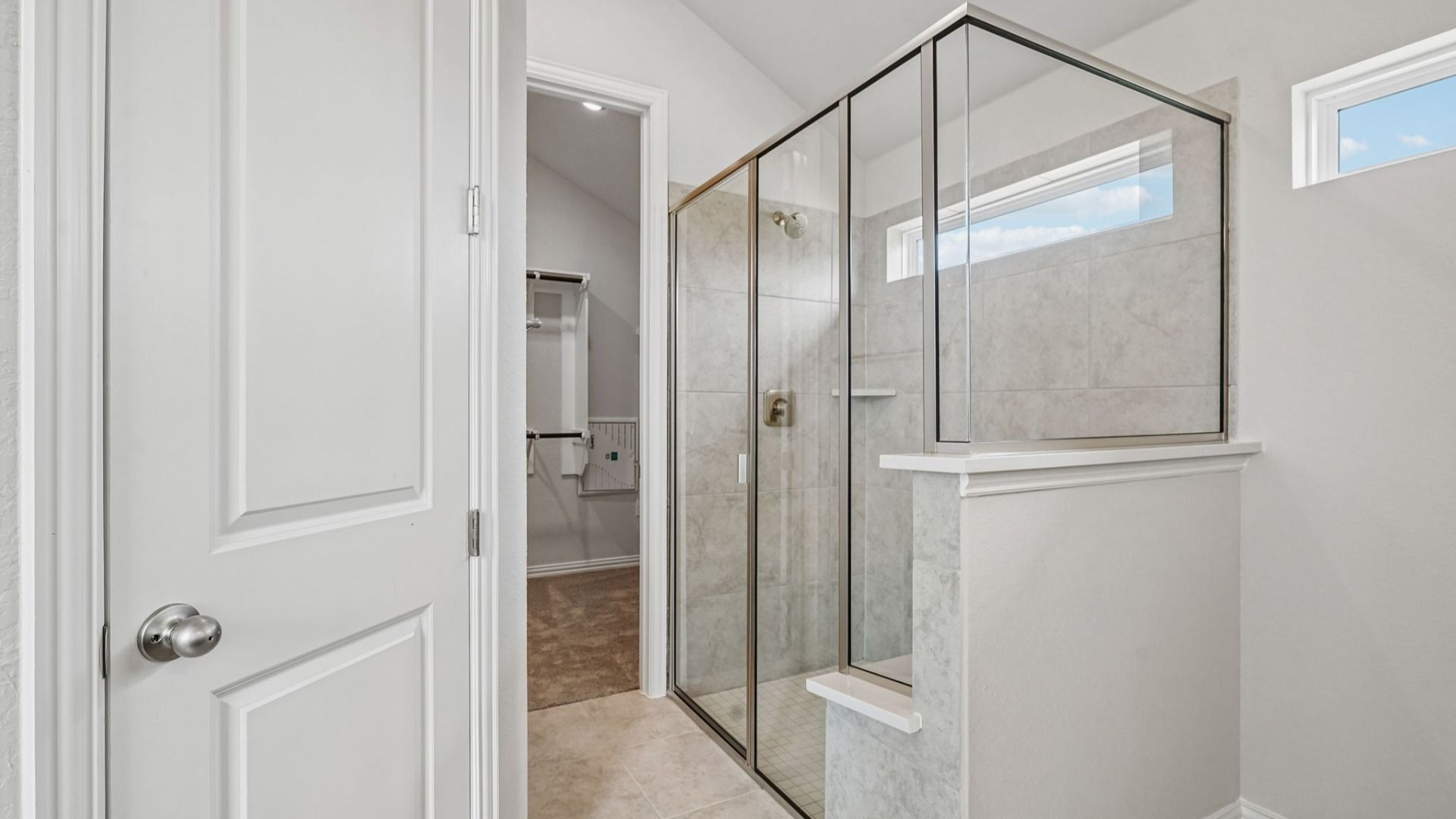 Owner's bath features a double vanity with space for a chair and a shower with a marble seat.