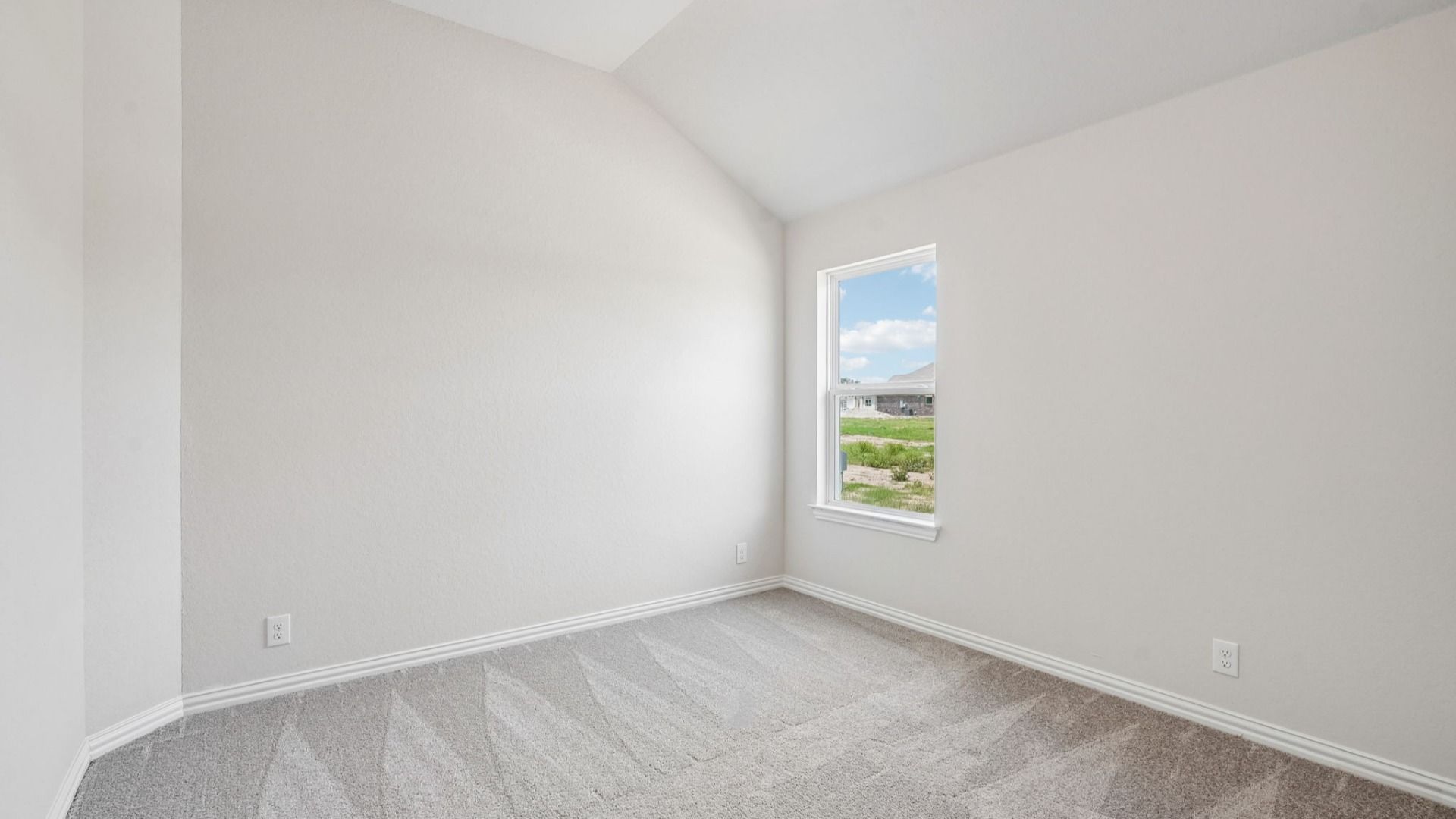 Secondary bedroom features a charming sloped ceiling that adds character and architectural appeal.