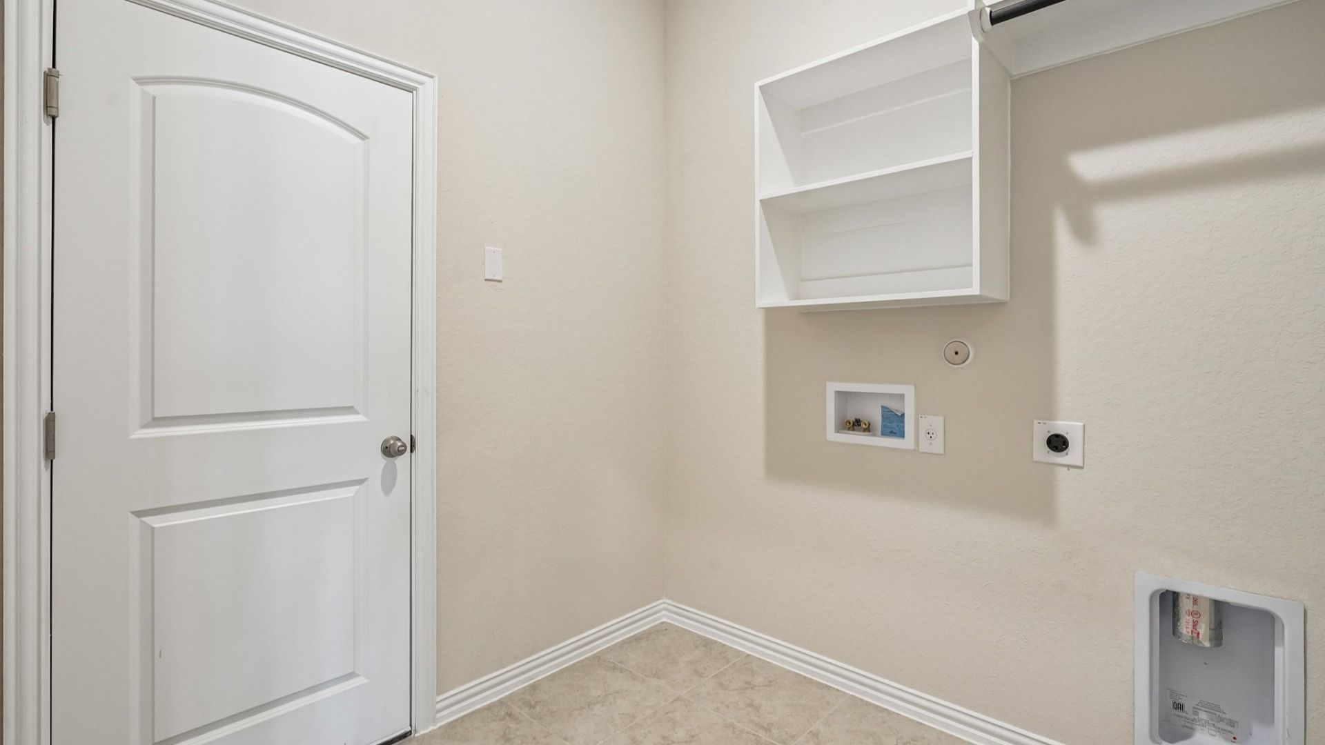 Dedicated laundry room features built-in shelving and a convenient clothing rod bar for added organization.