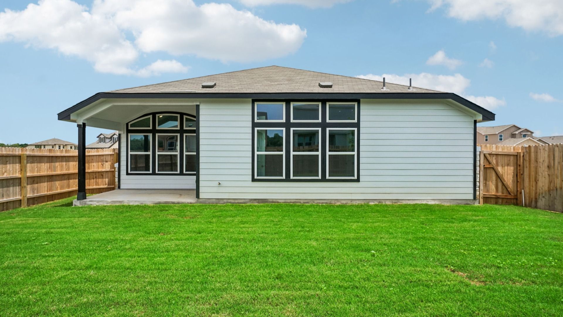 Large backyard features a covered patio and a tree that complements the outdoor space.