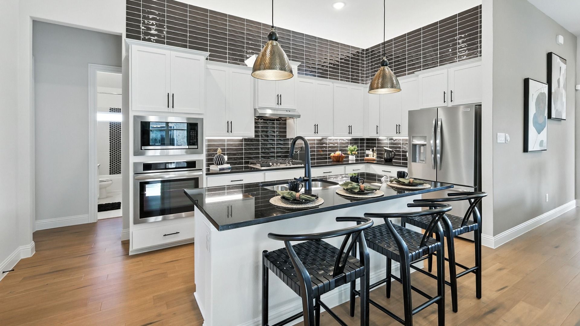 Bright modern kitchen with a large island, stainless steel appliances, and elegant designer finishes.