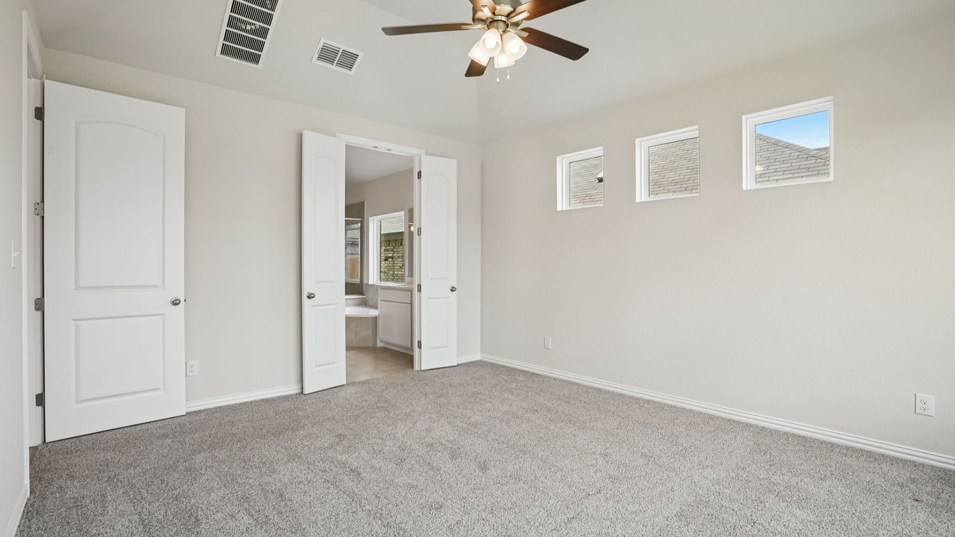Owner's Suite includes plenty of windows for natural light, along with a ceiling fan for additional comfort