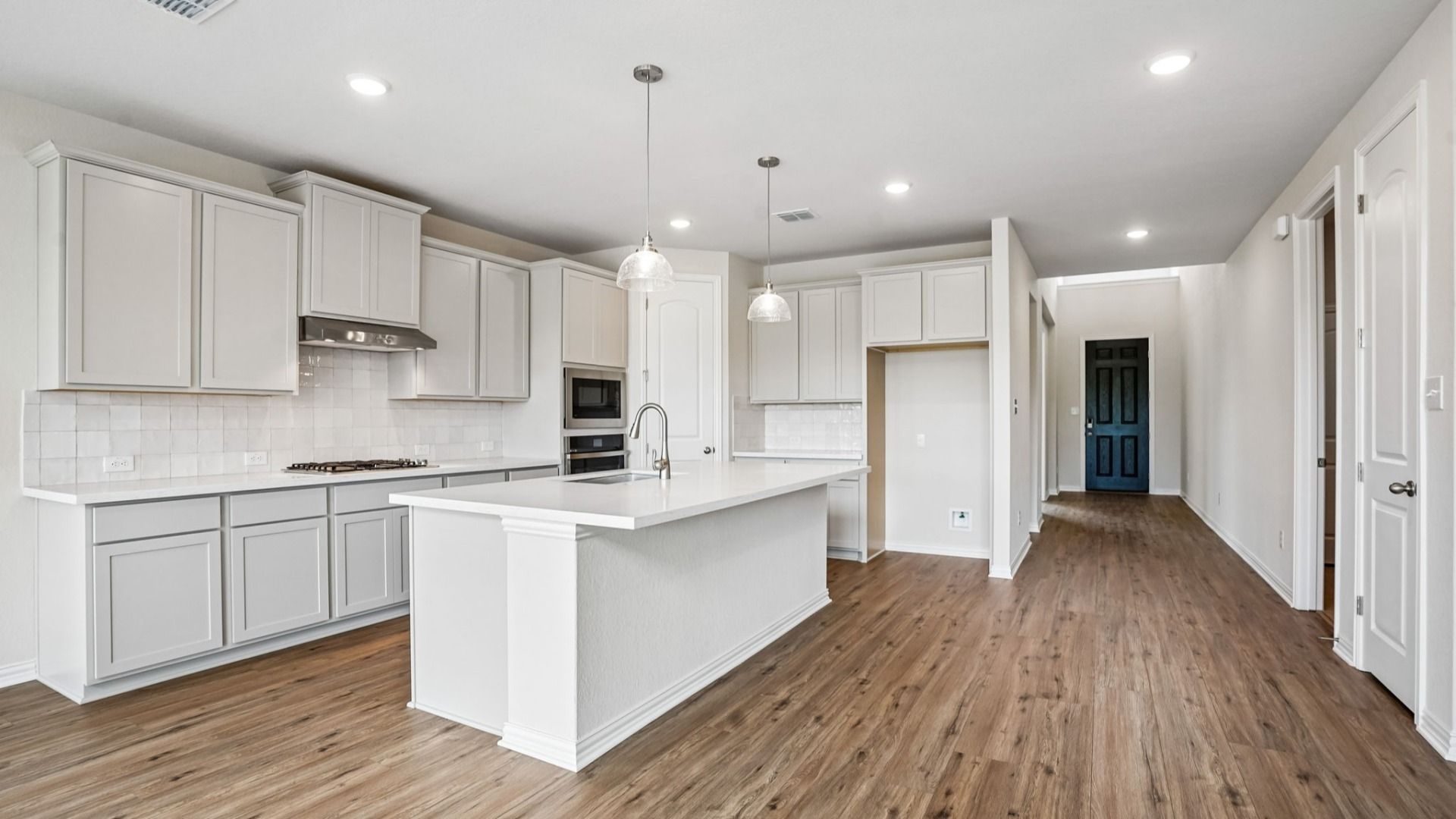 Modern Kitchen Features Built-in Appliances, Pendant Island, and Center Island
