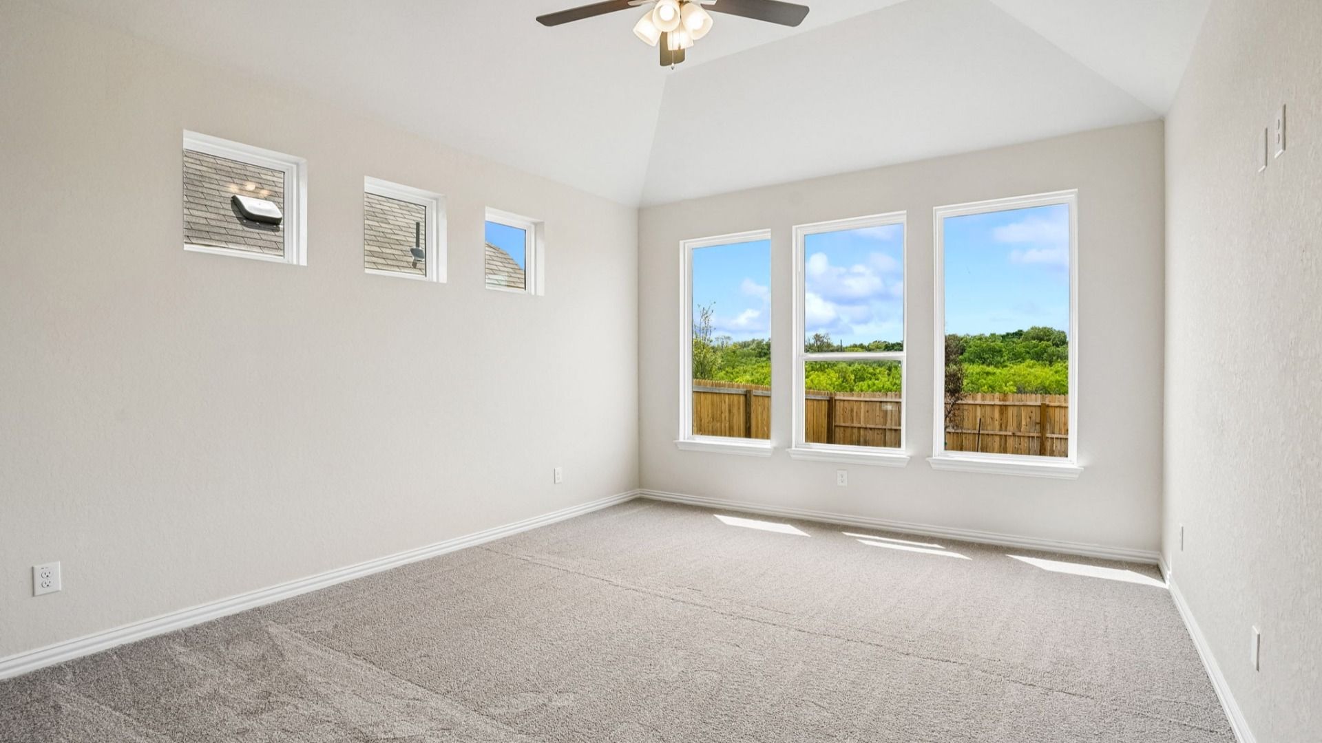 Owner's Suite features plenty of windows allowing natural light to flow, a raised ceiling, and ceiling fan