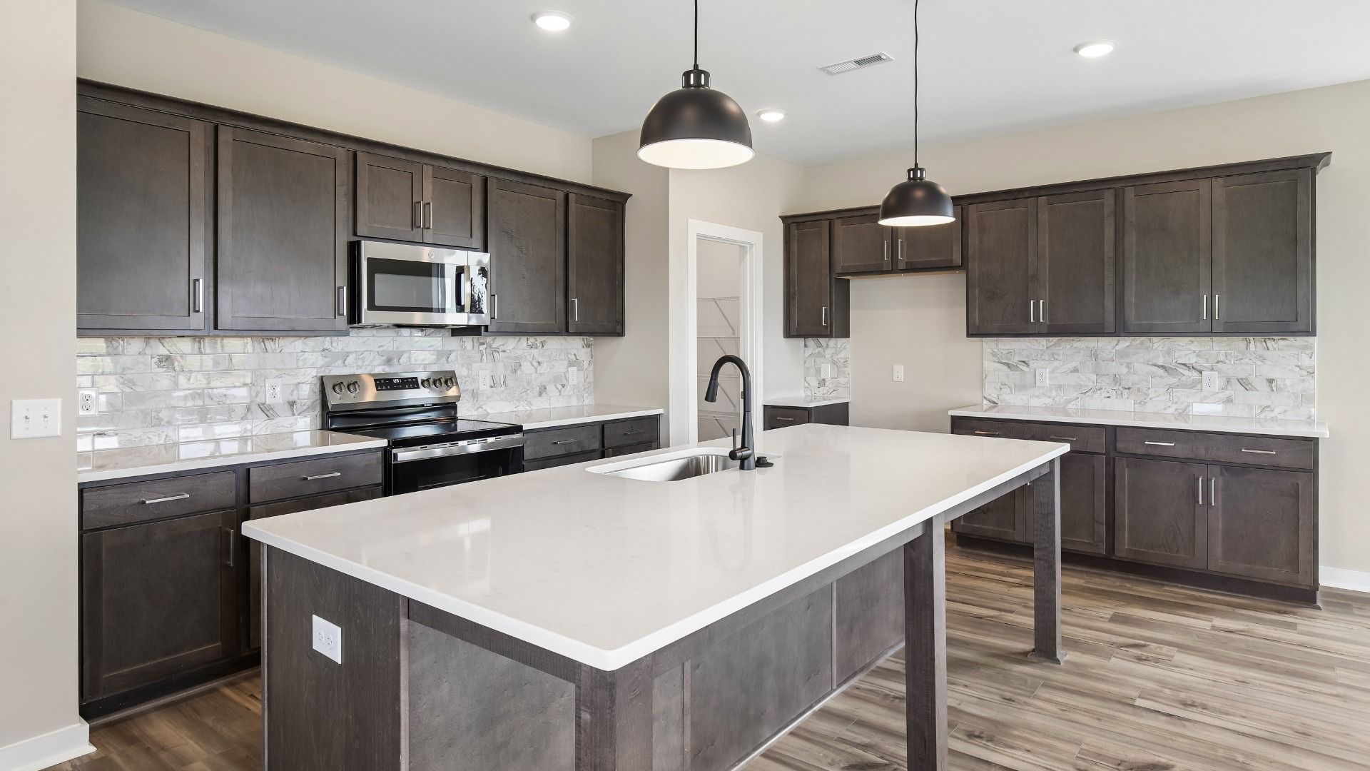 Gorgeous Kitchen from a Juniper plan home with quartz countertops and tile backsplash