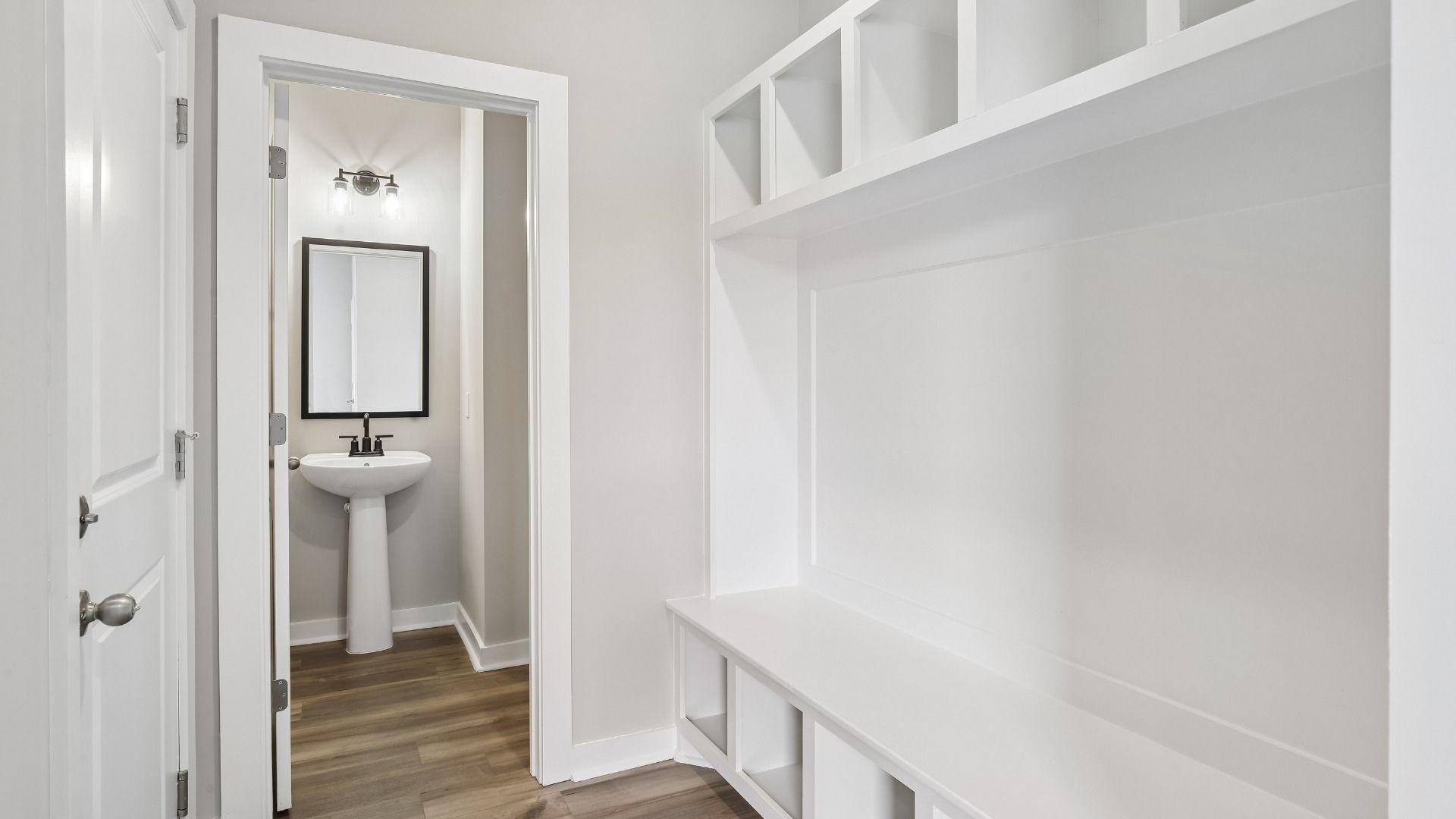 Powder room and built-in drop zone storage and bench near front entry