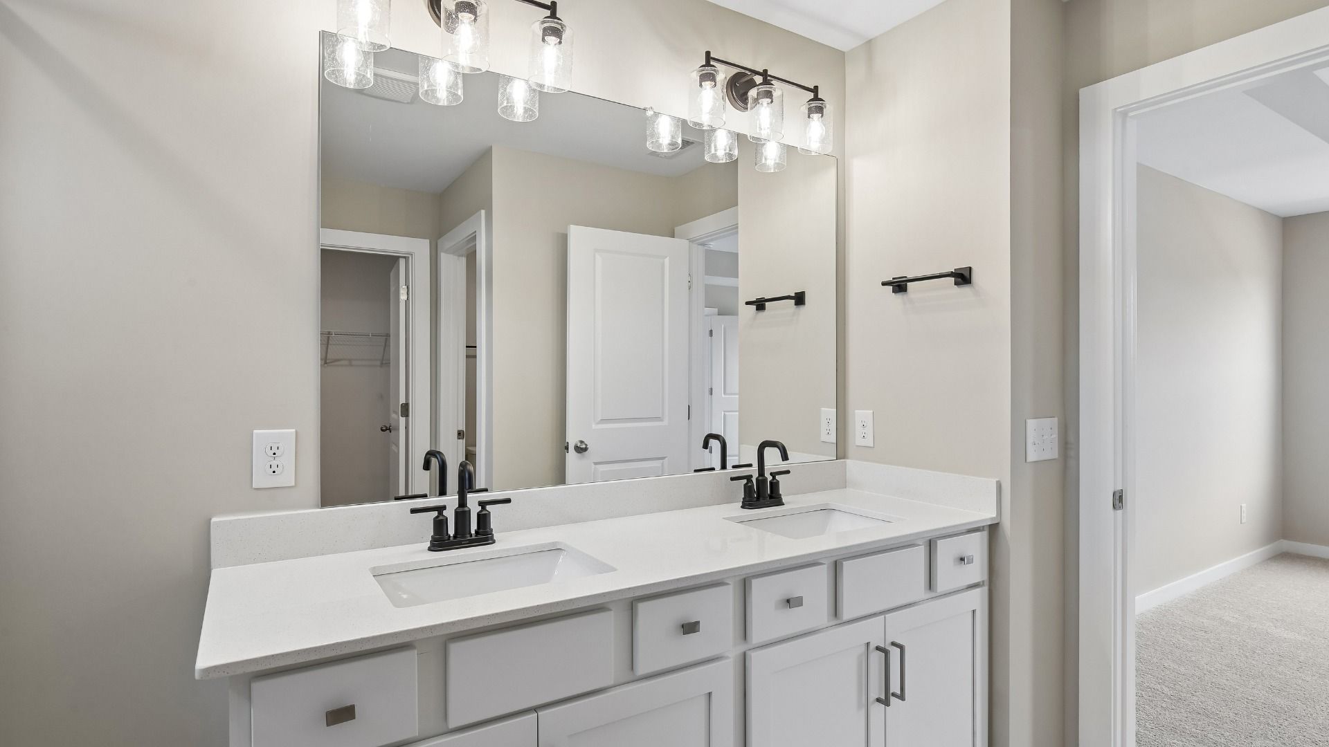 Bathroom with tile flooring and shower with glass enclosure, along with dual vanity