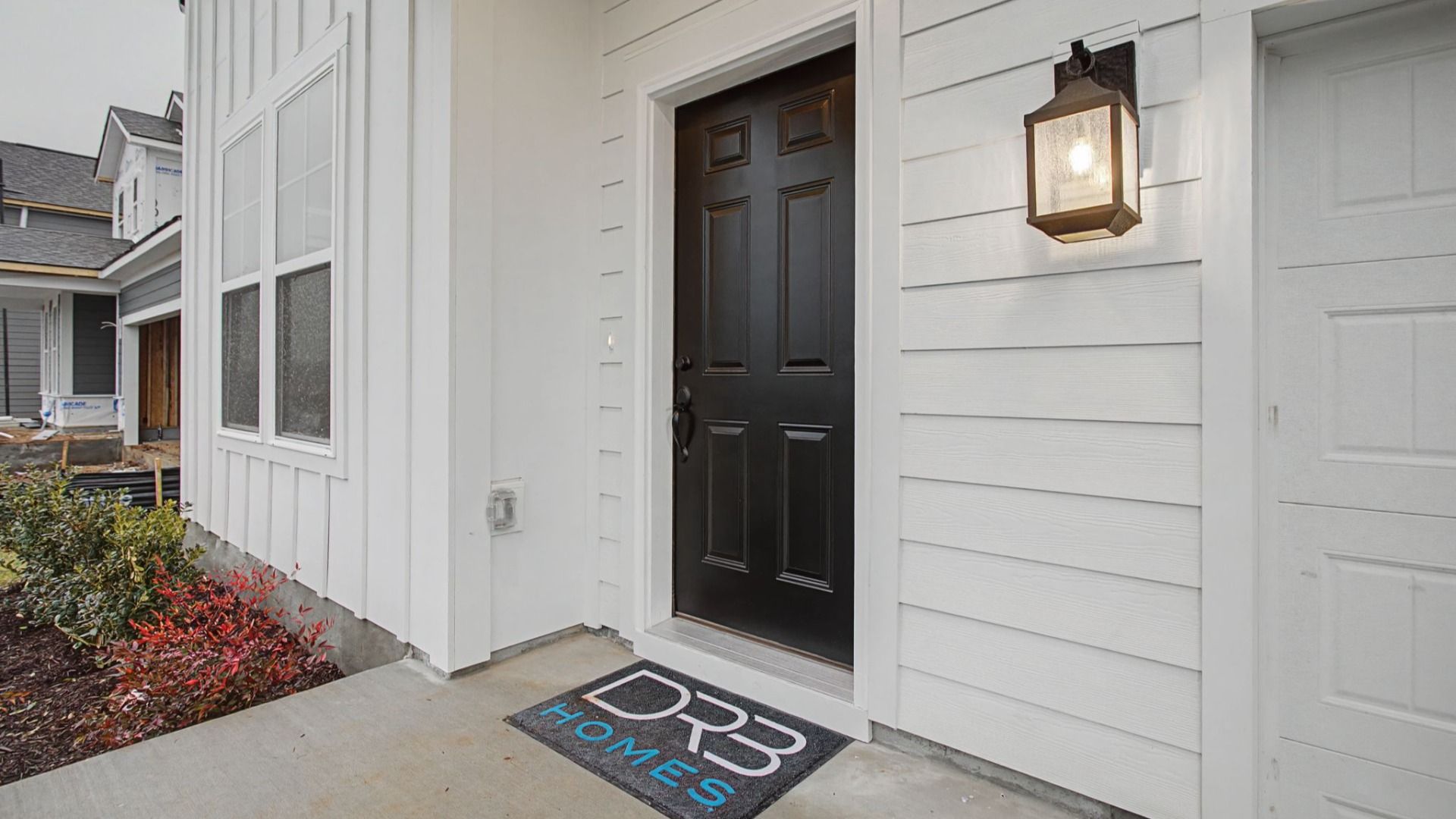 Front door to a home with carriage lighting