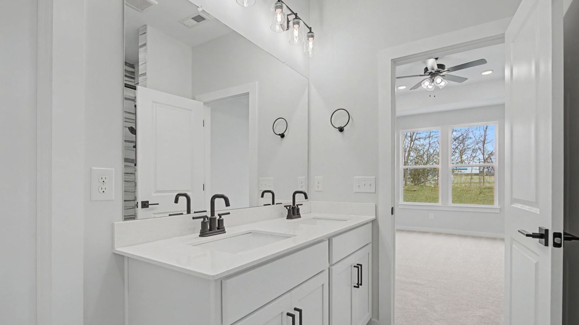Bathroom with dual sink vanity, quartz countertop, and tiled floors and shower
