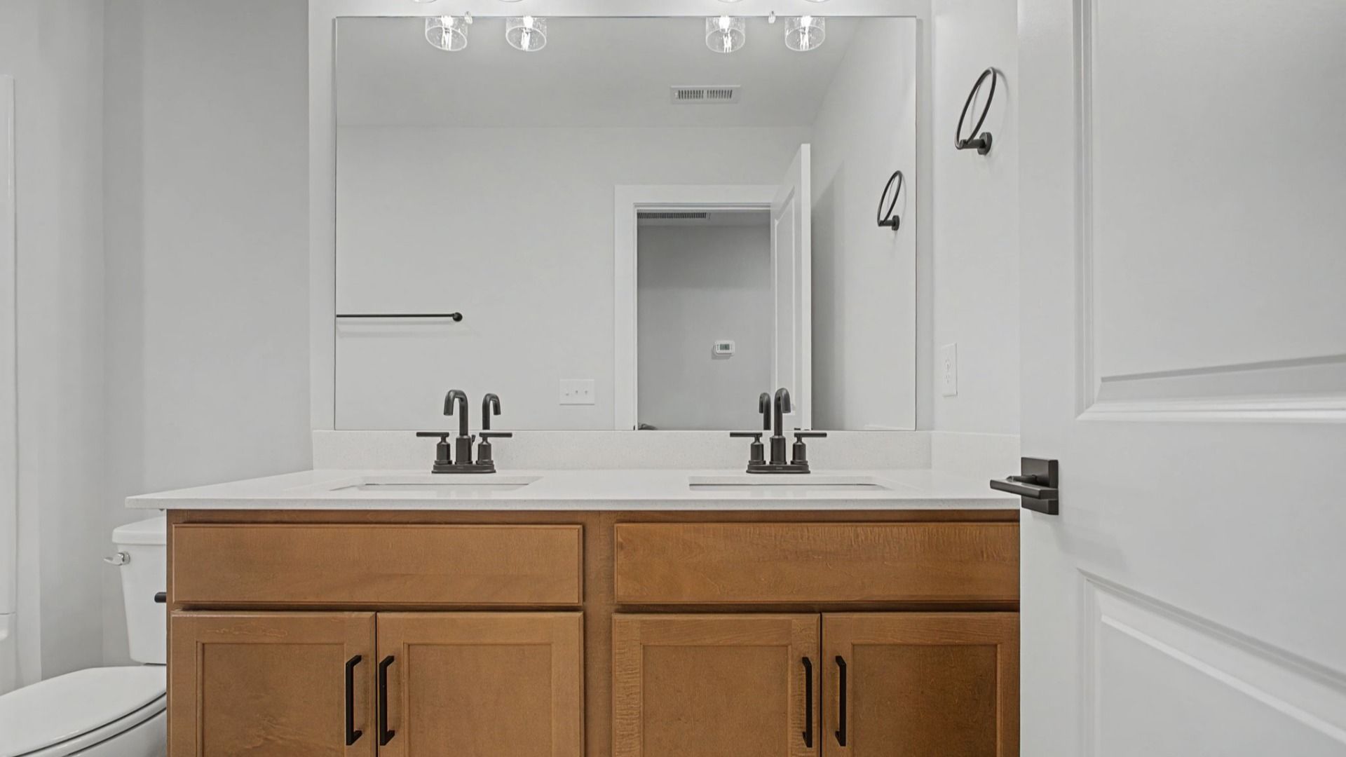 Shared Secondary Bathroom with natural-colored cabinets and premium hardware