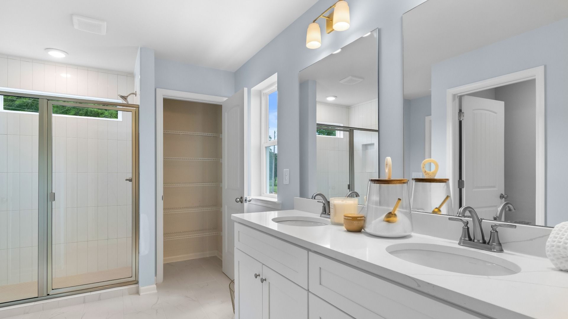 Relax and refresh in the primary suite tiled shower and dual-sink vanity