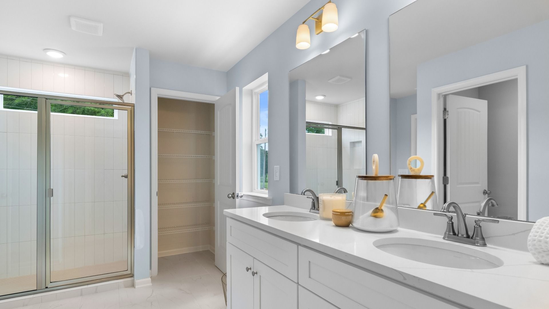 Relax and refresh in the primary suite tiled shower and dual-sink vanity