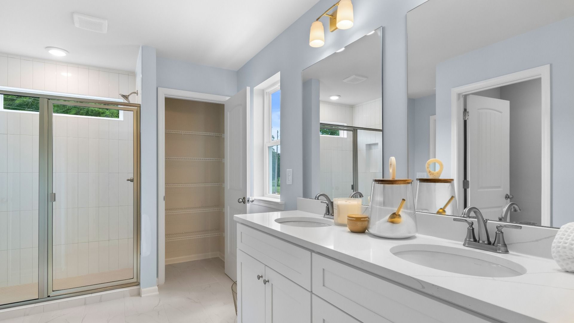 Relax and refresh in the primary suite tiled shower and dual-sink vanity