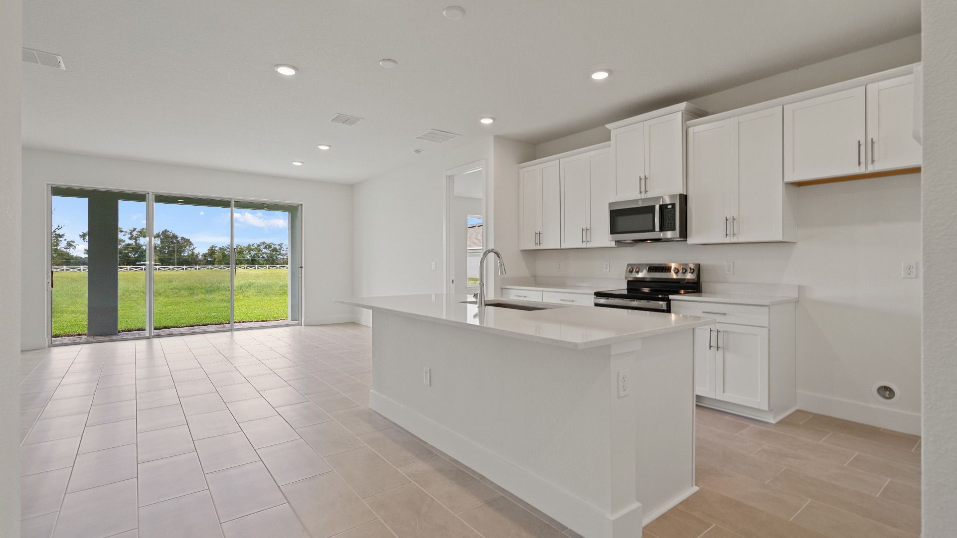 Kitchen and Island in the Buttonwood Floor Plan by DRB Homes in Ardisia Park in New Smyrna Beach