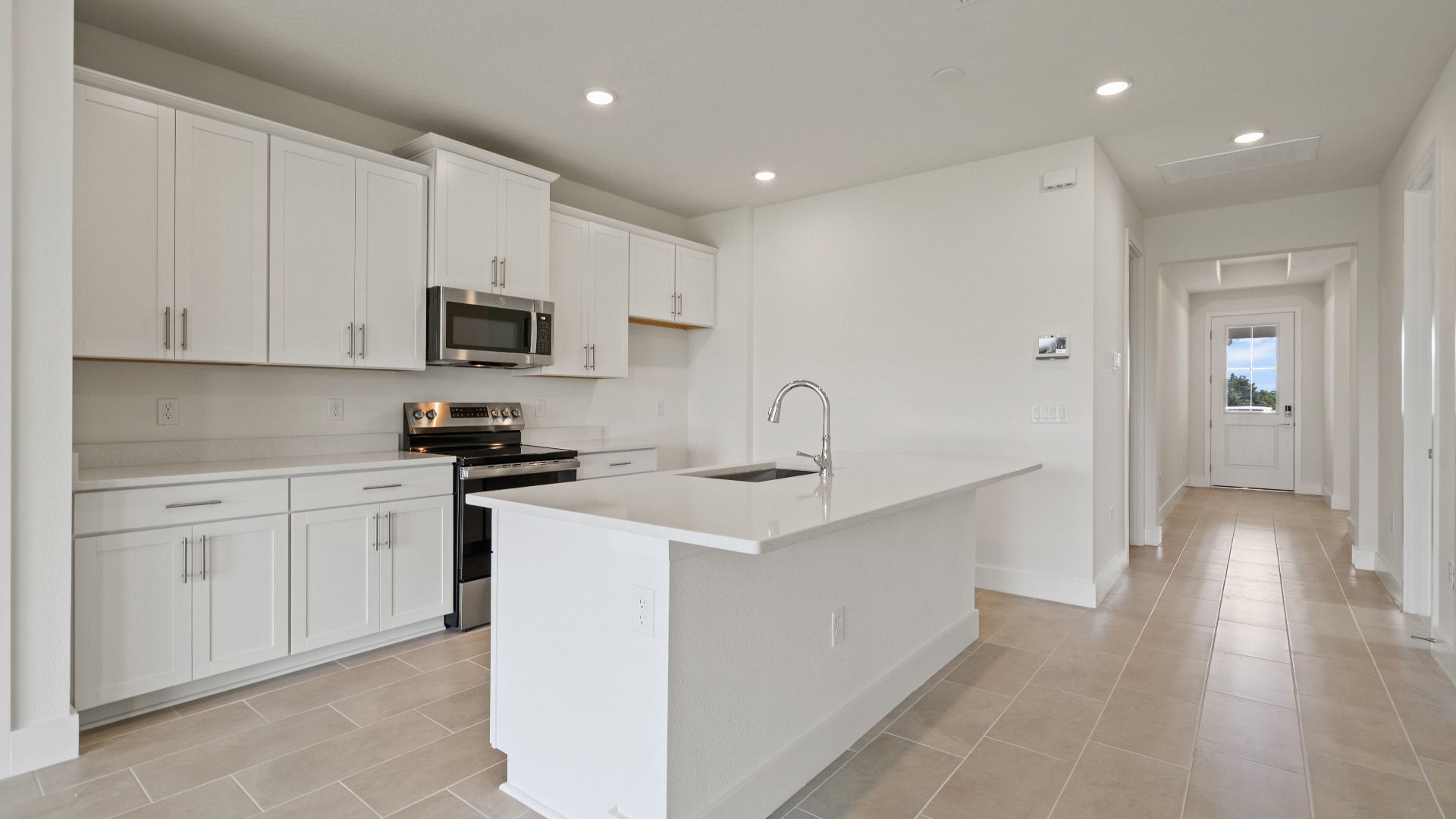 Kitchen and Island in the Buttonwood Floor Plan by DRB Homes in Ardisia Park in New Smyrna Beach