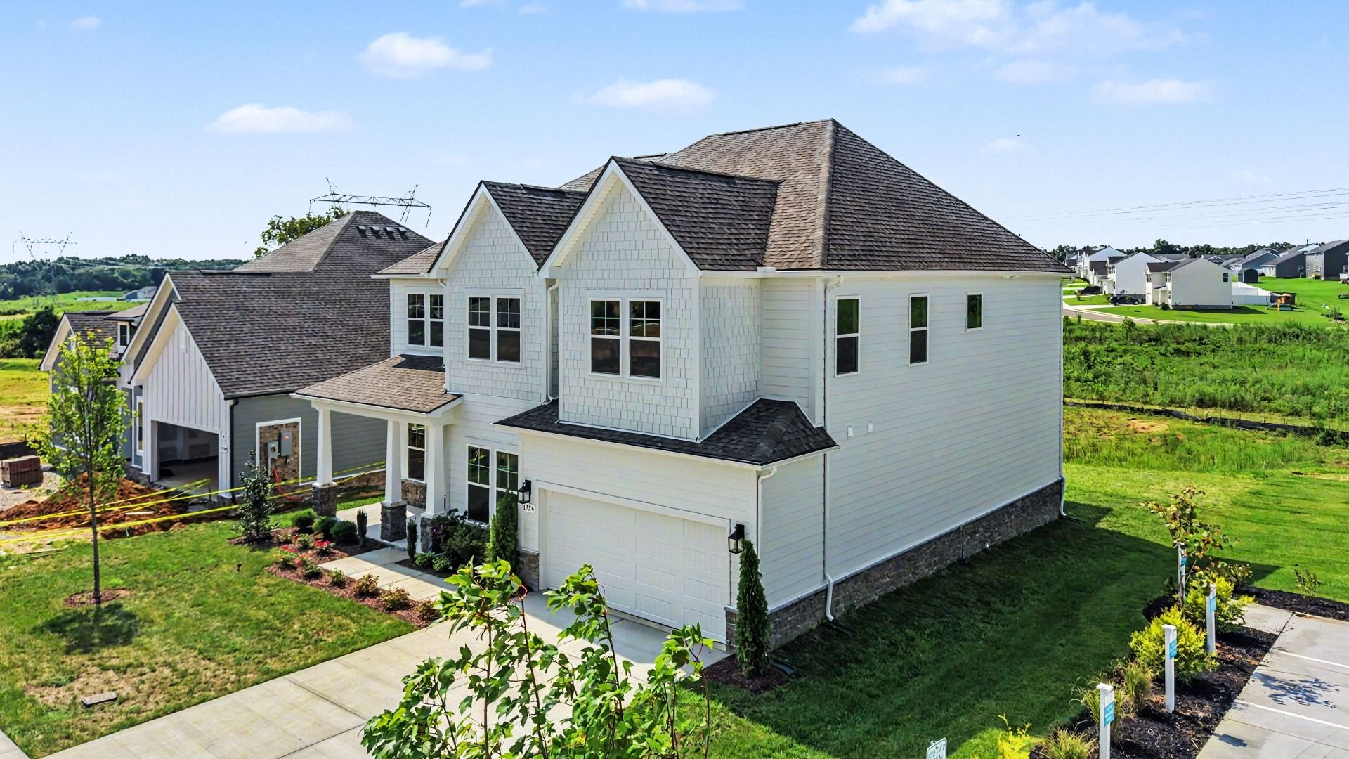 Exterior of home with white siding, stone accents, and covered front porch