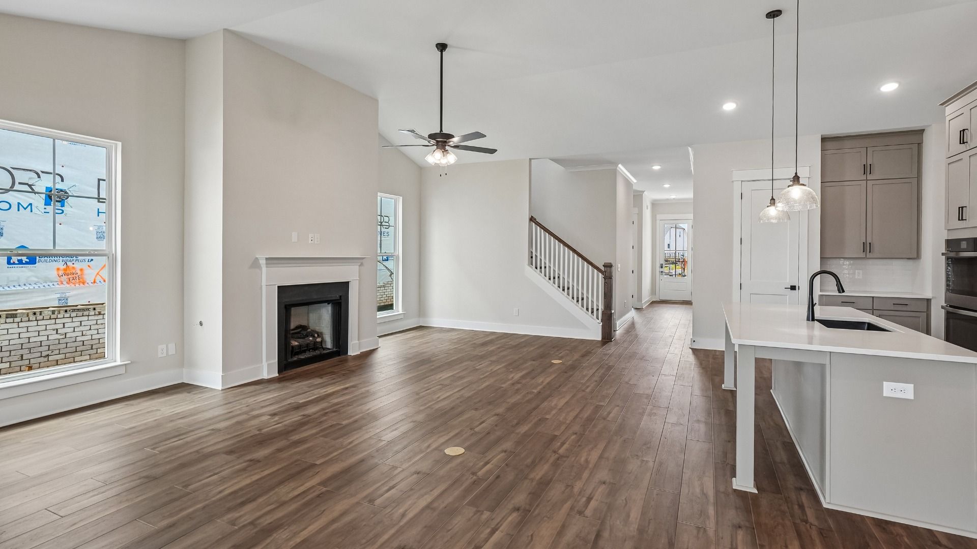 Open Concept layout with kitchen, staircase, and living room with fireplace