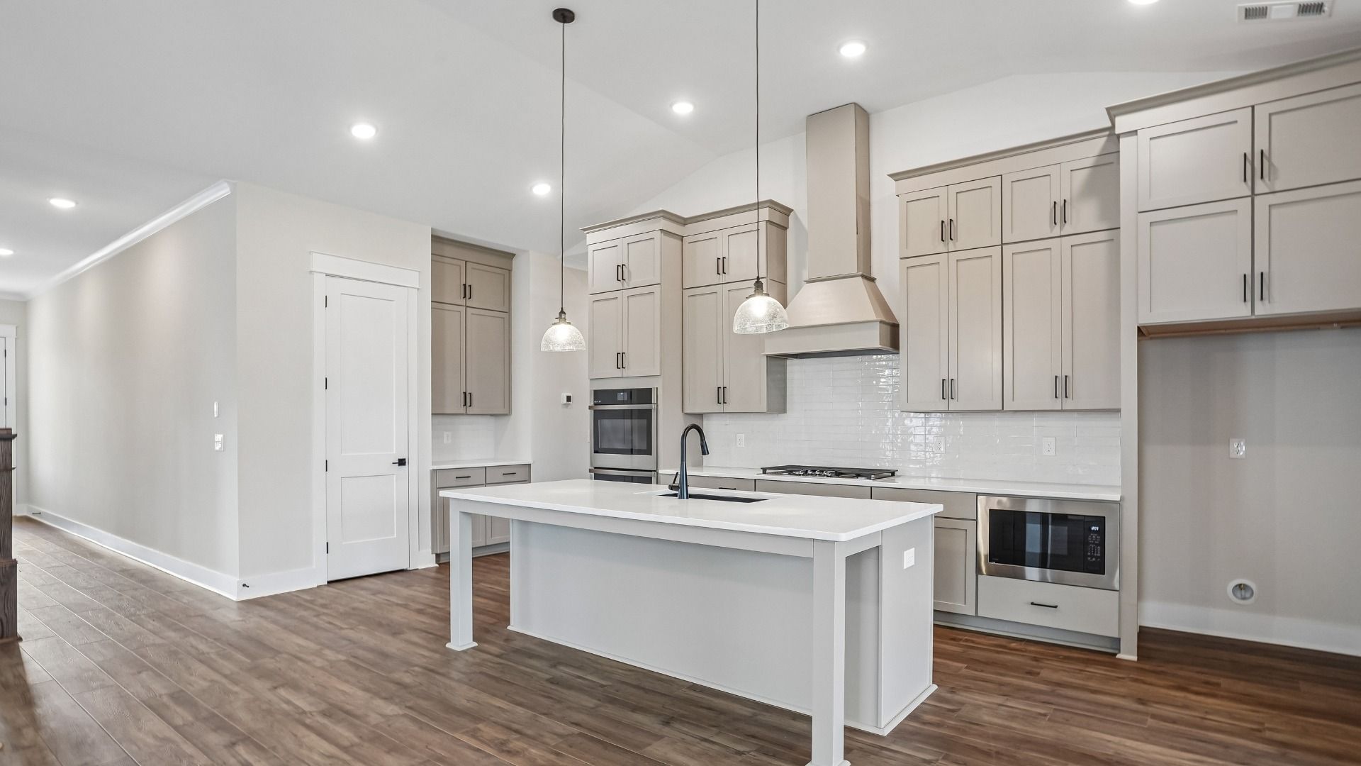 Kitchen with ceiling-height cabinetry, quartz countertops, walk-in pantry, built-in ovens, and gas range