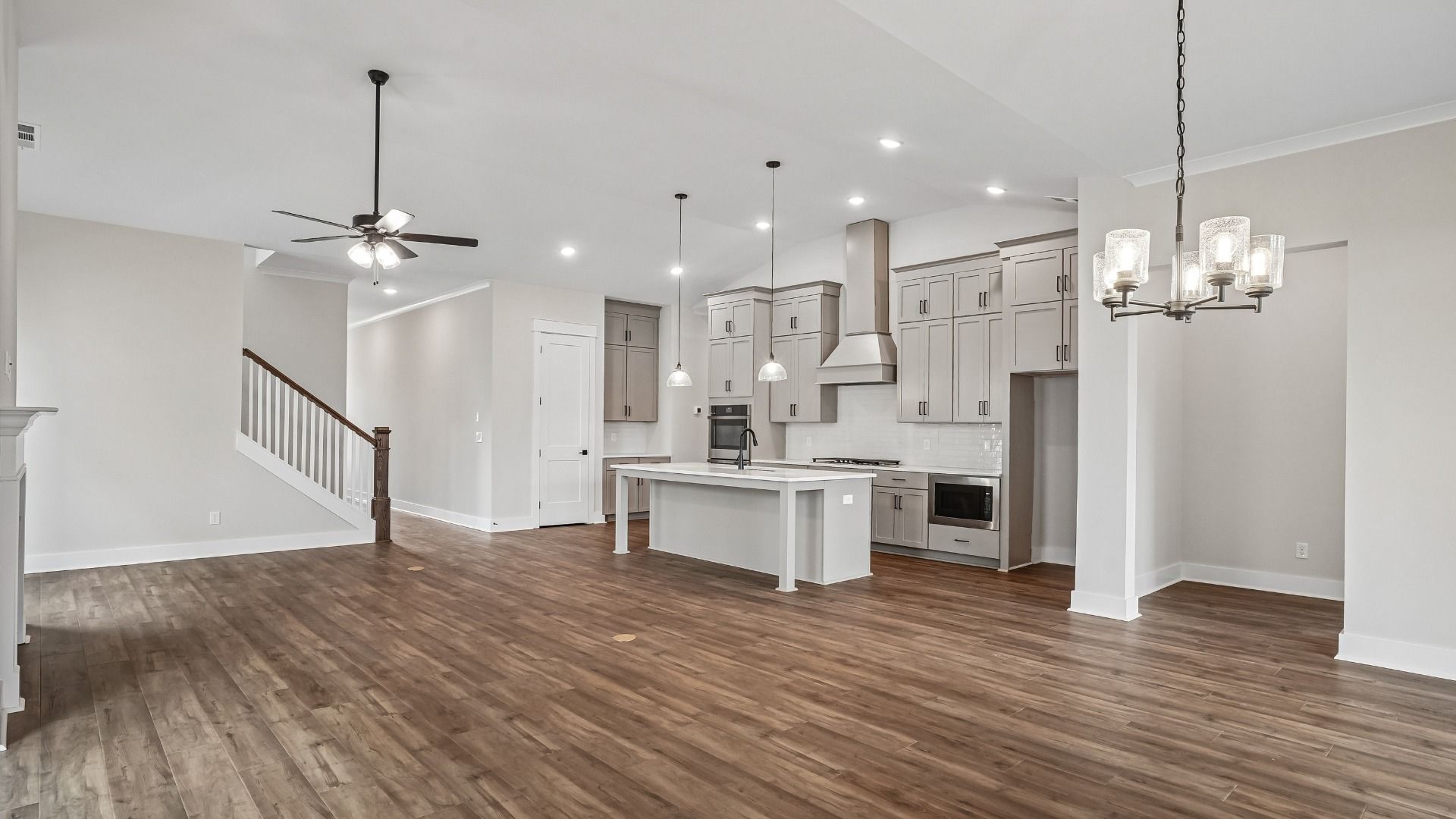 View of living room and kitchen from dining area with vaulted ceilings