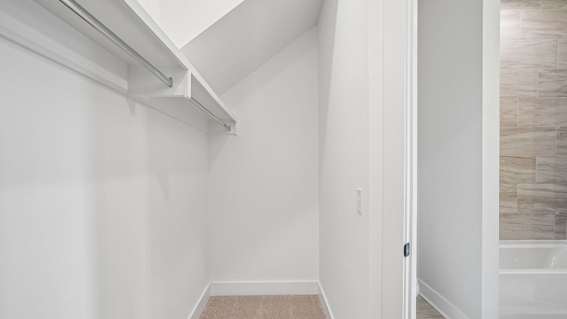 Guest closet near bathroom with built-in shelving