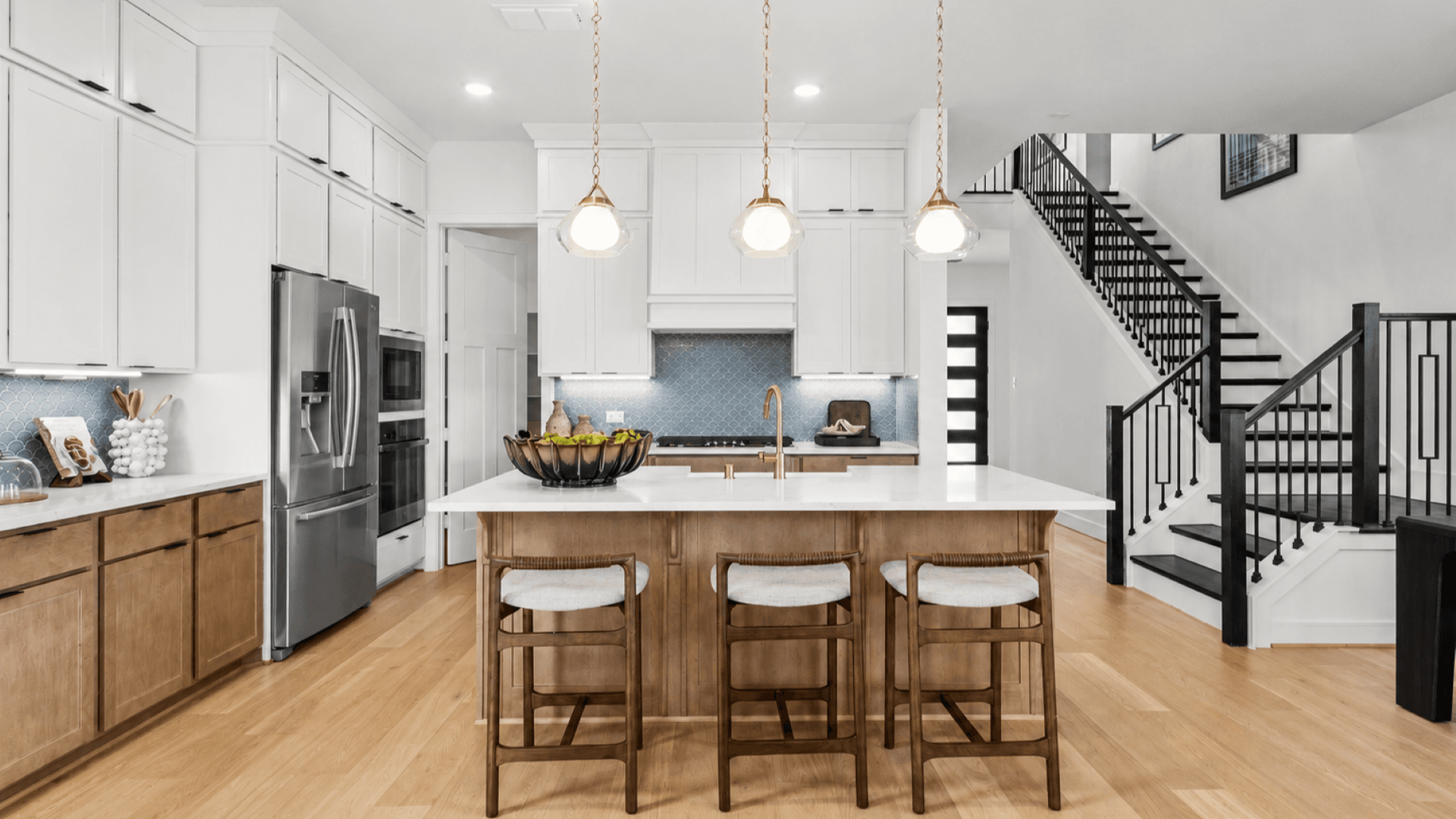 Modern kitchen in Bridgeland Central with soft wood tones and crisp white cabinets and counters.