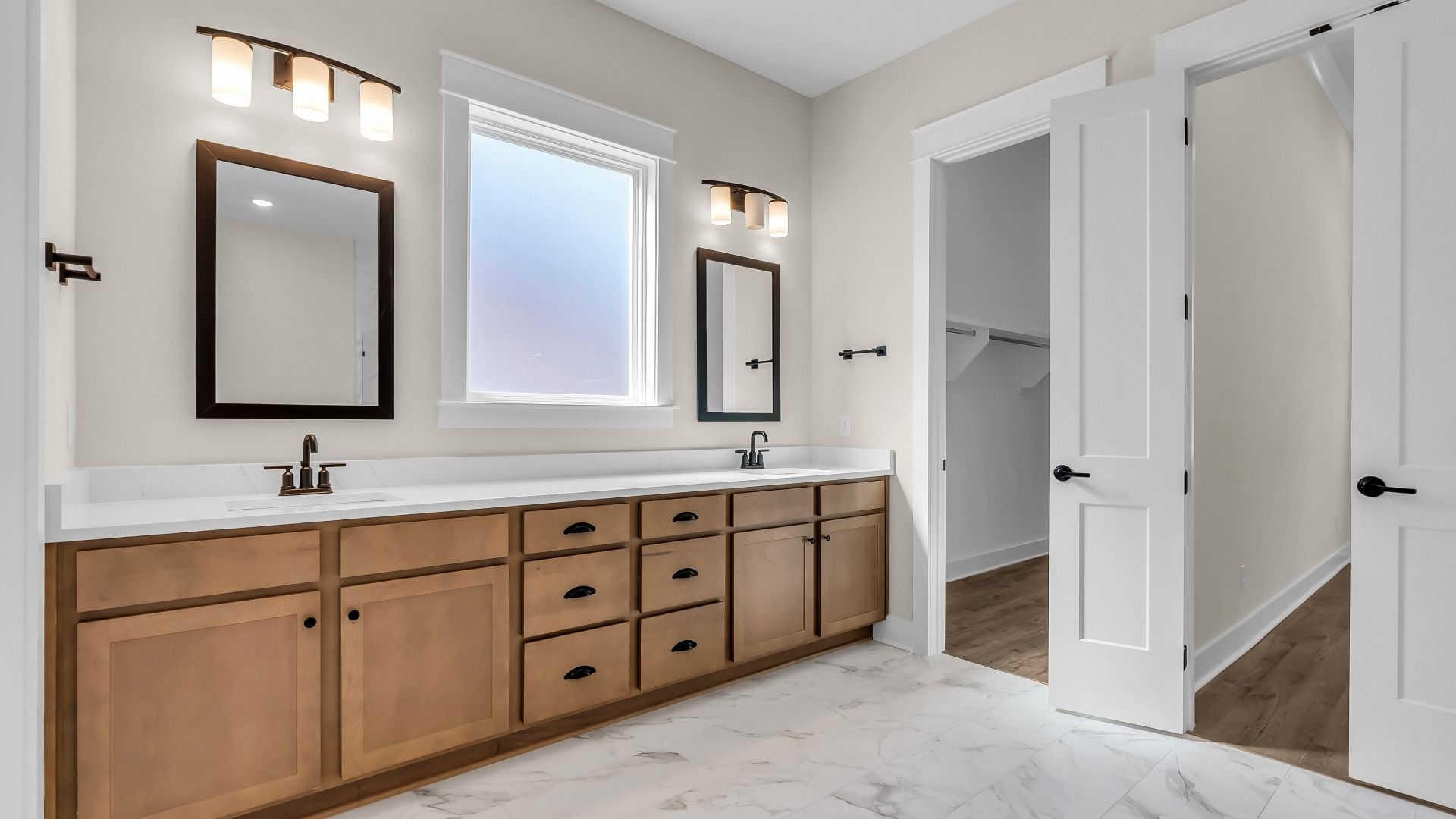 Primary bathroom with large dual vanity and walk-in closet. (Representative of completed home)