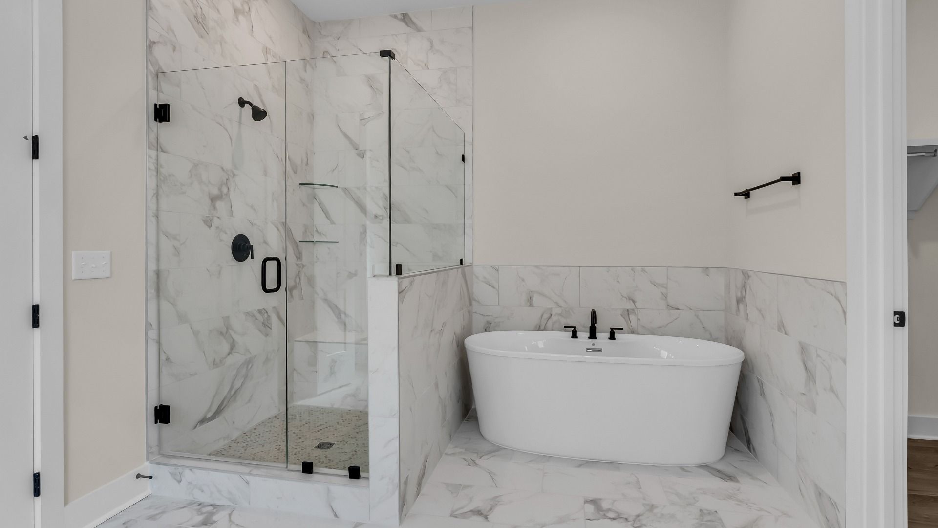 Primary bathroom with frameless glass and tiled shower and freestanding tub (Representative of completed home)