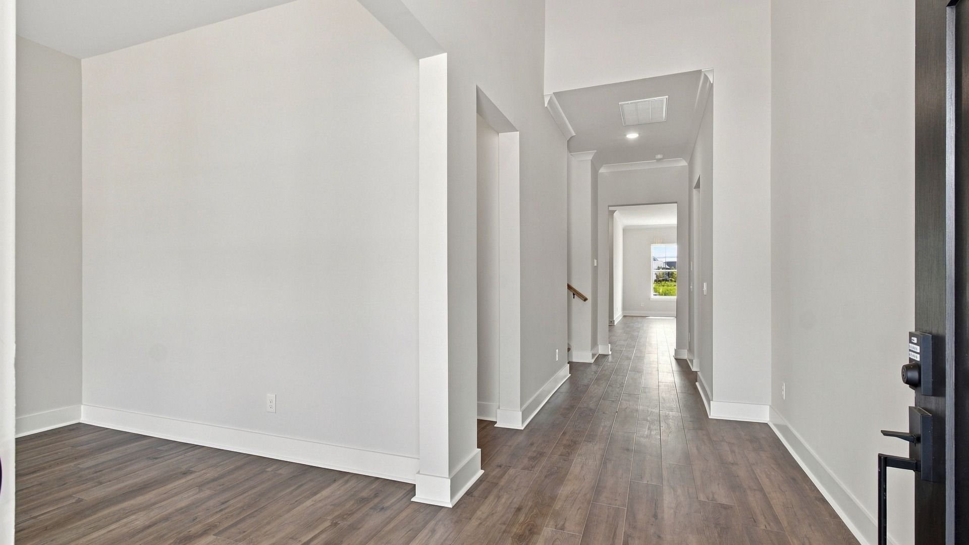 Spacious front door entry way with living space and hallway.